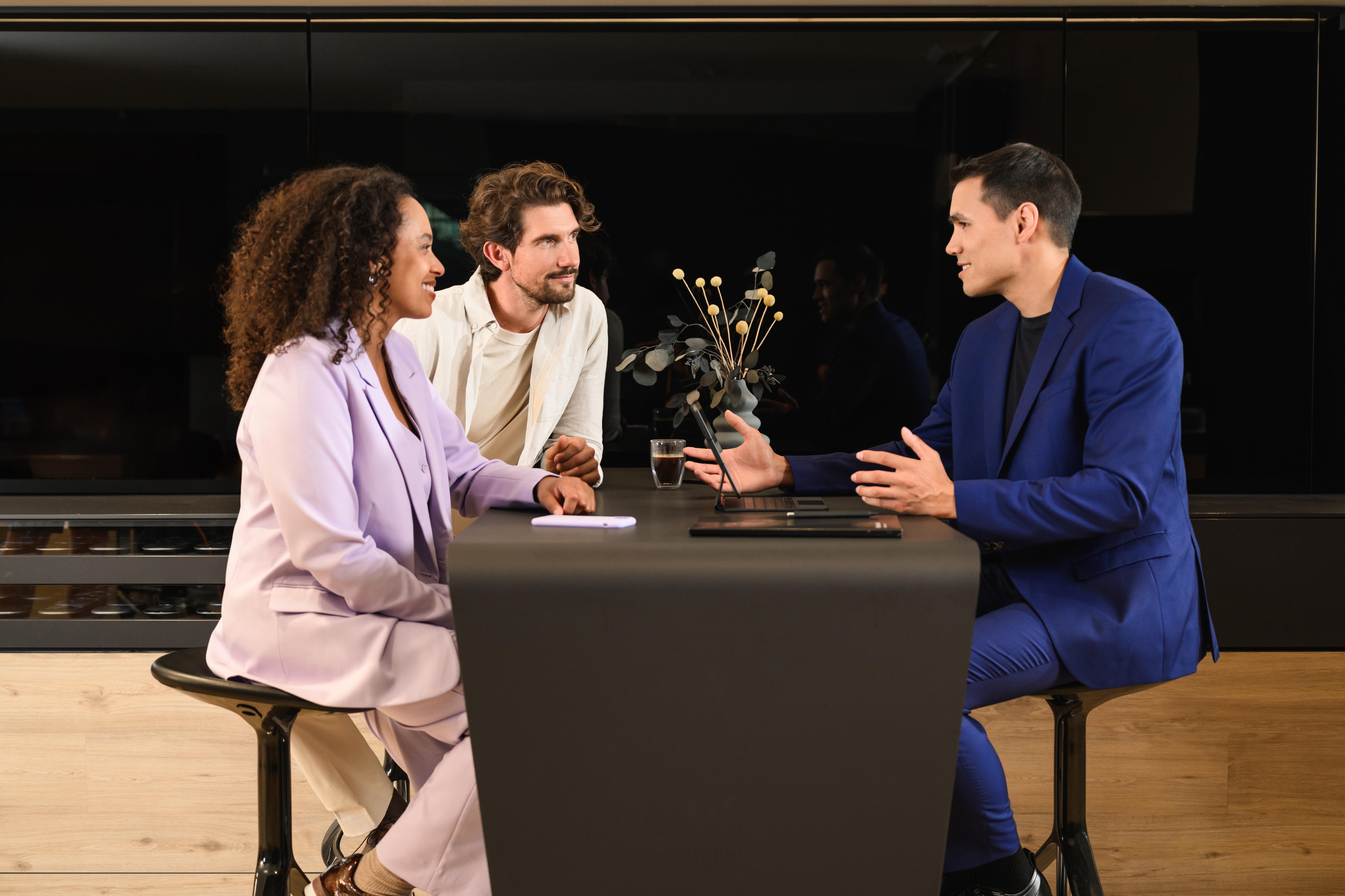 Trzy spółki - jedna organizacja | Mercedes-Benz Financial Services Trzy osoby siedzące przy jednym stole.