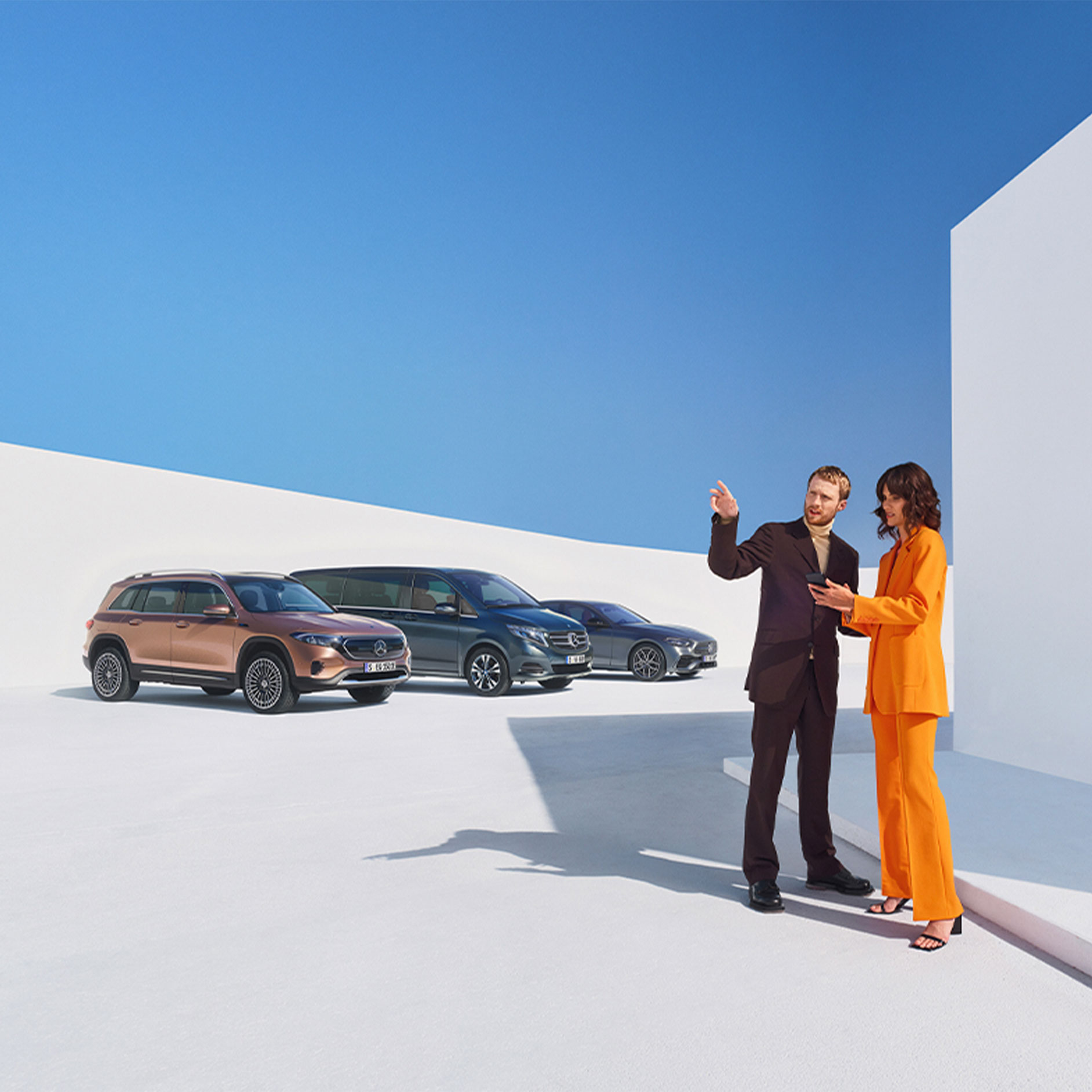 Cyfrowe Dodatki dla klientów biznesowych | Mercedes-Benz Mężczyzna i kobieta przed kilkoma pojazdami Mercedes-Benz.