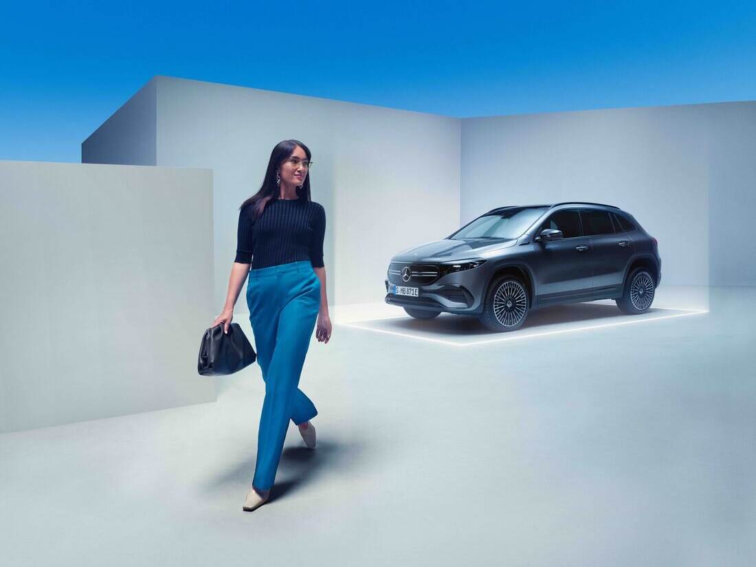 Kobieta oddala się od swojego zaparkowanego pojazdu Mercedes-Benz.
