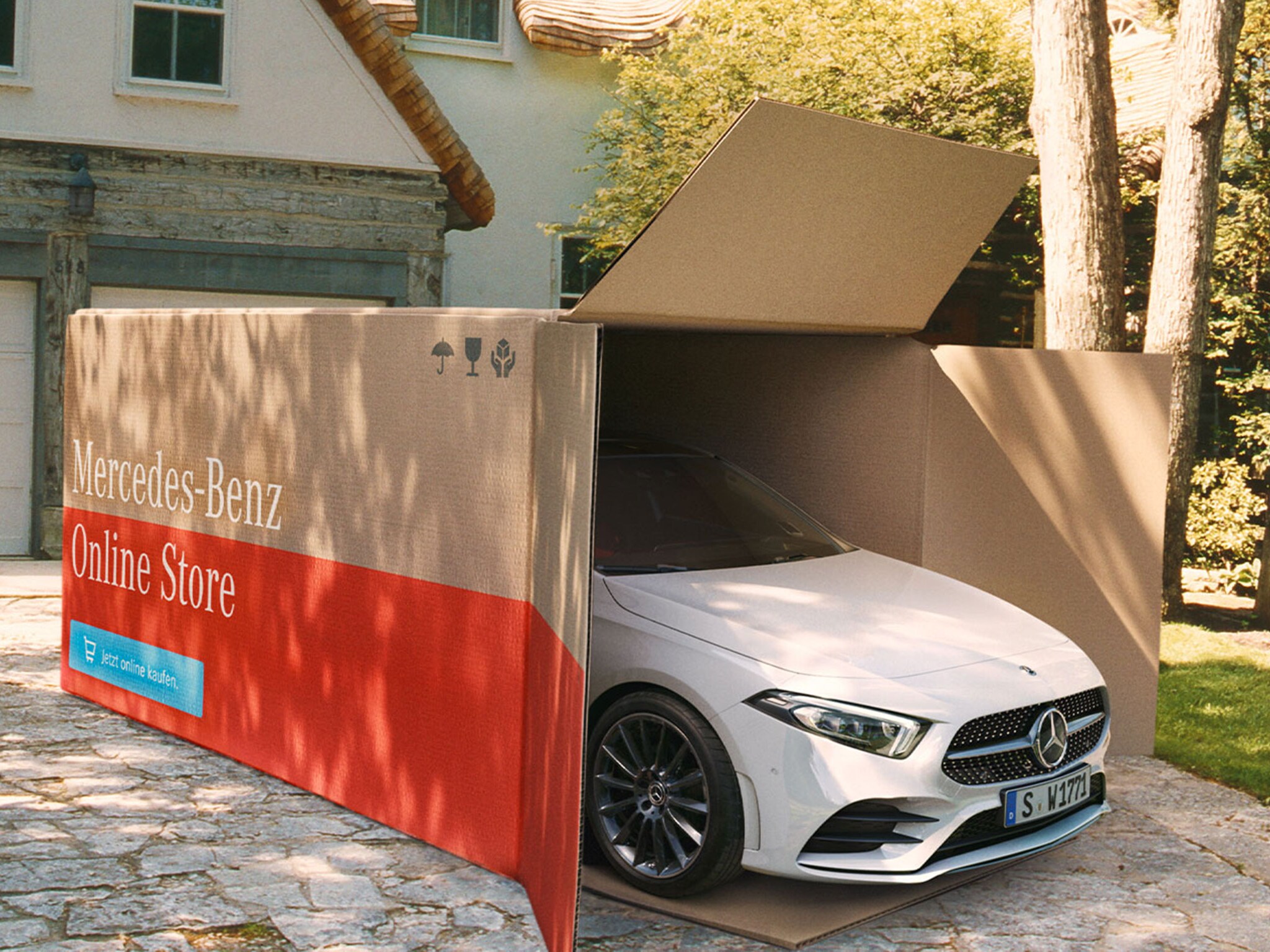 Biała Klasa A Mercedes-Benz wyjeżdża z ogromnego kartonowego pudła.