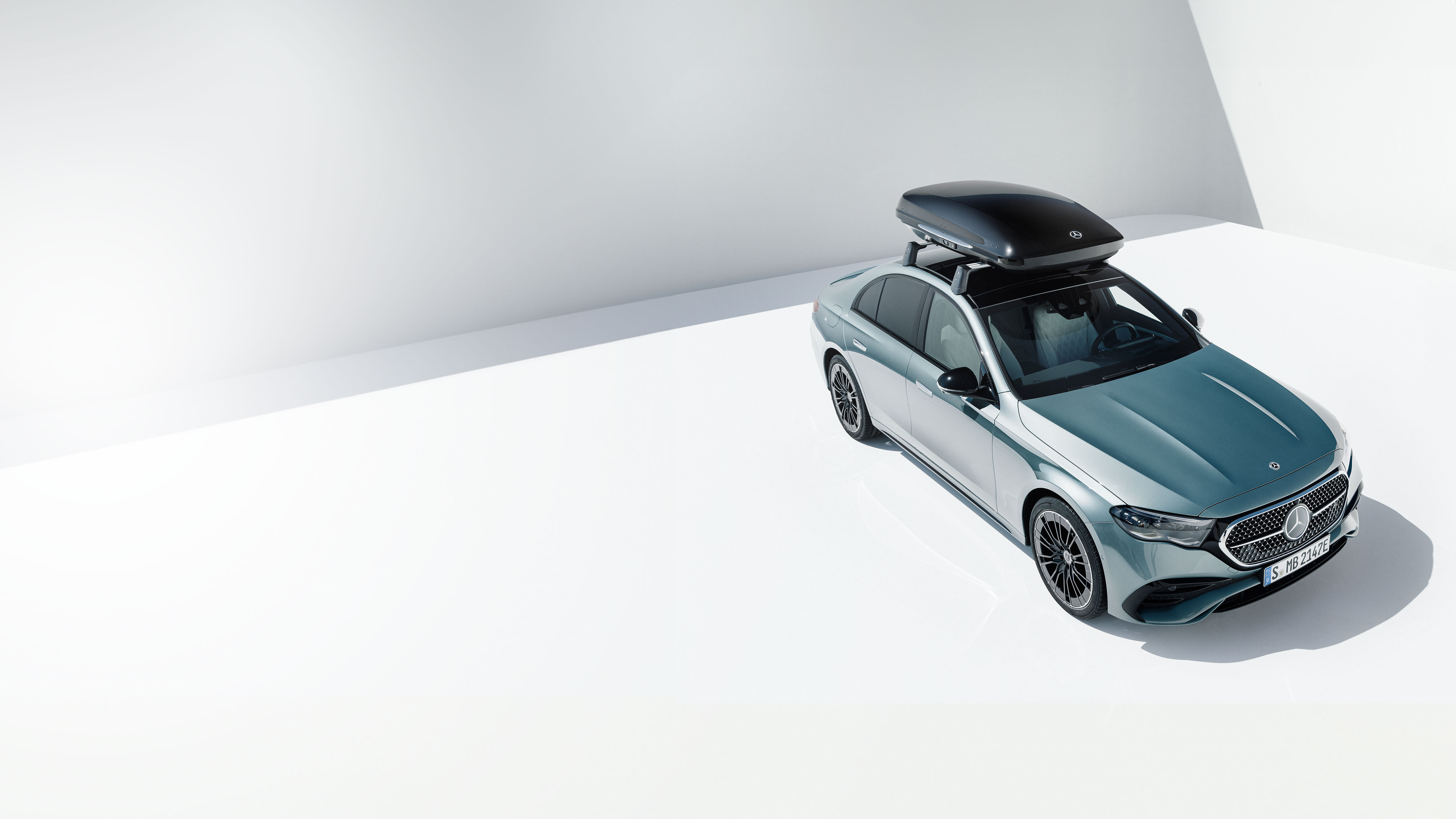 Akcesoria techniczne Mercedes-Benz Srebrny Mercedes-Benz z bagażnikiem dachowym.
