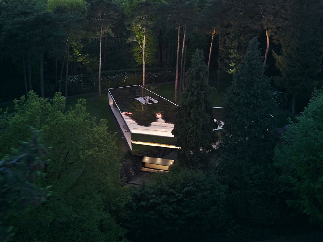 Budynek ukryty pośród wysokich drzew.