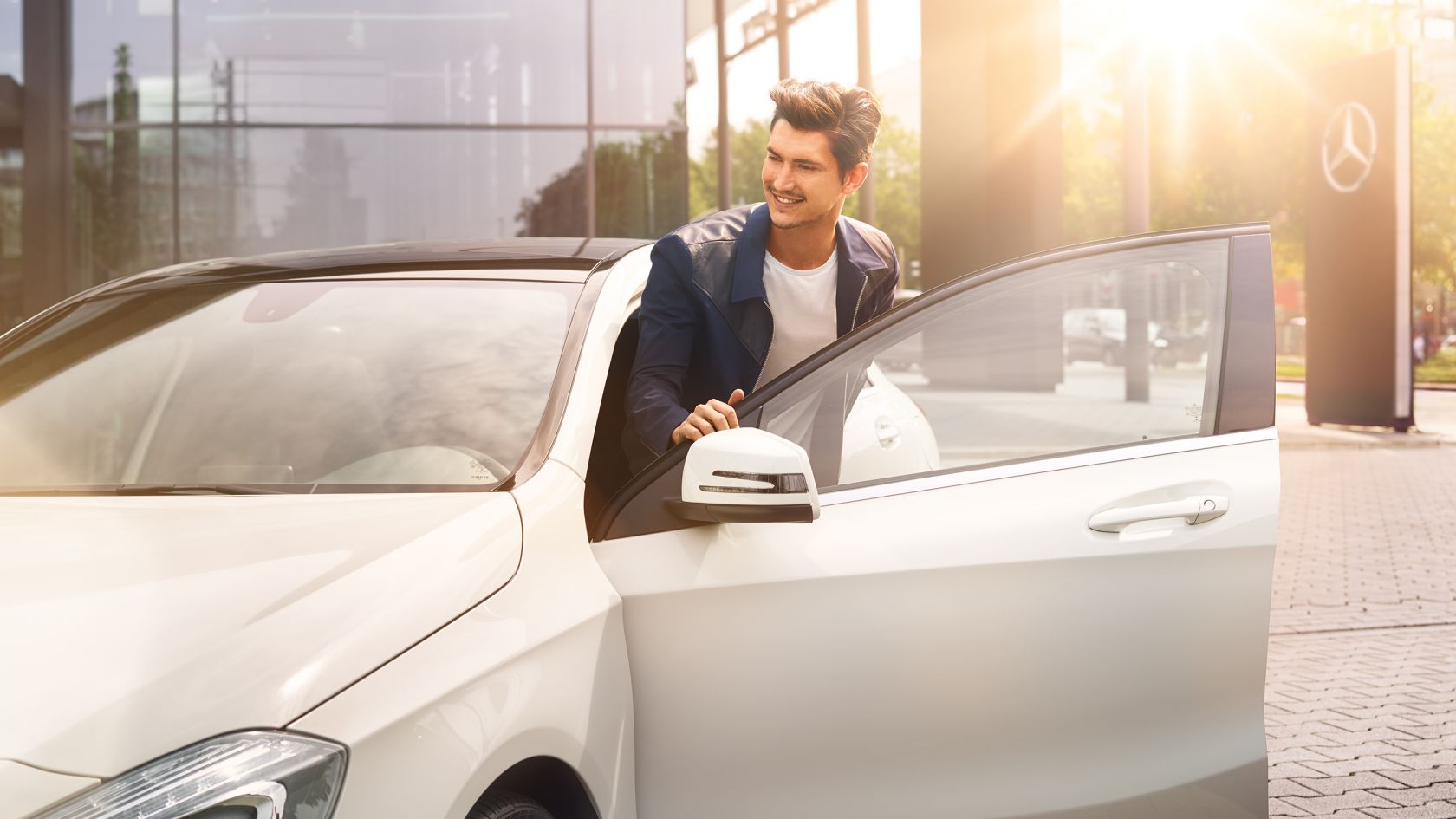 Mercedes-Benz Certified: certyfikowane samochody używane Mężczyzna wsiada do białego Mercedesa.