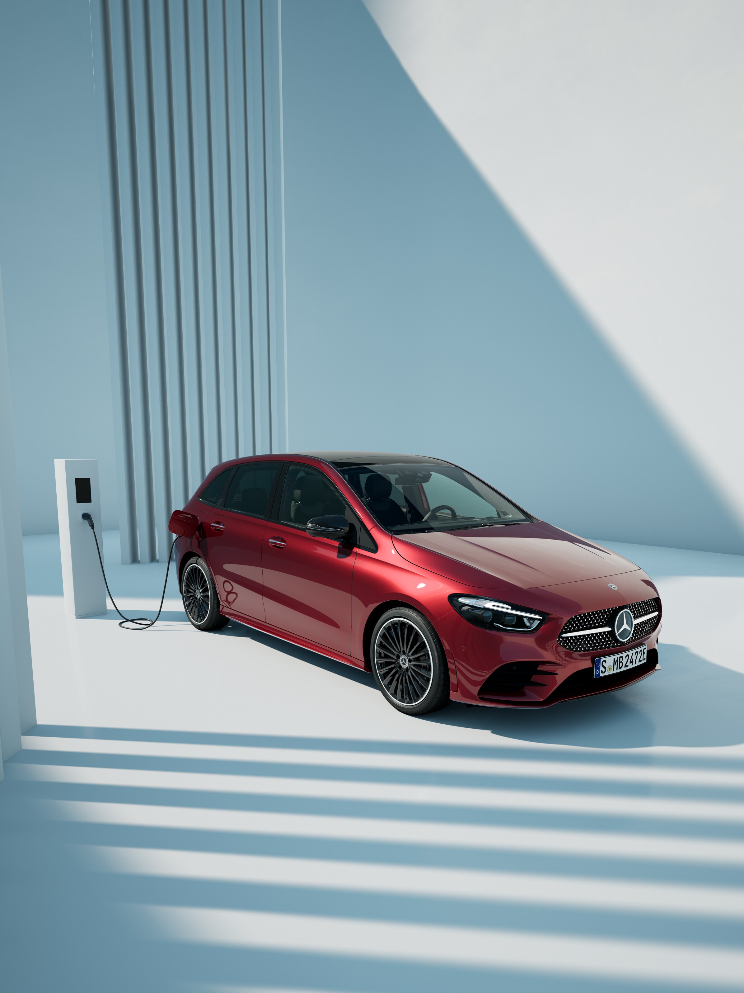 Czerwona Klasa B Mercedes-Benz przy stacji ładowania.