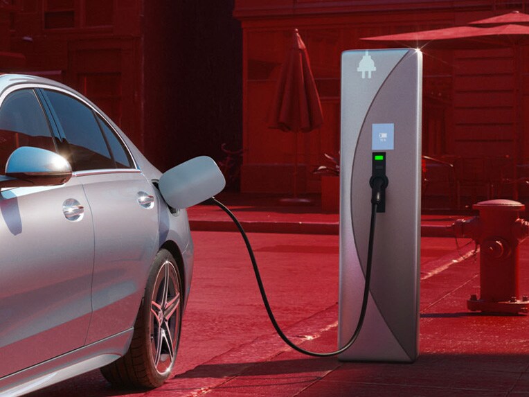 Ładowanie limuzyny Klasy C Mercedes-Benz w technologii plug-in hybrid na publicznej stacji ładowania.