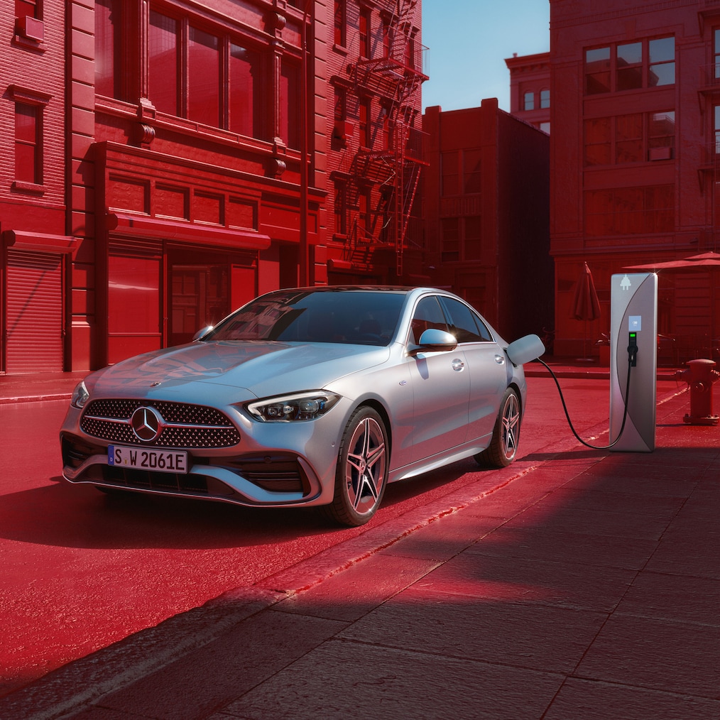 Dynamiczny widok Klasy C Limuzyna Mercedes-Benz (ujęcie podczas jazdy) lub pojazd stojący na stacji ładowania.