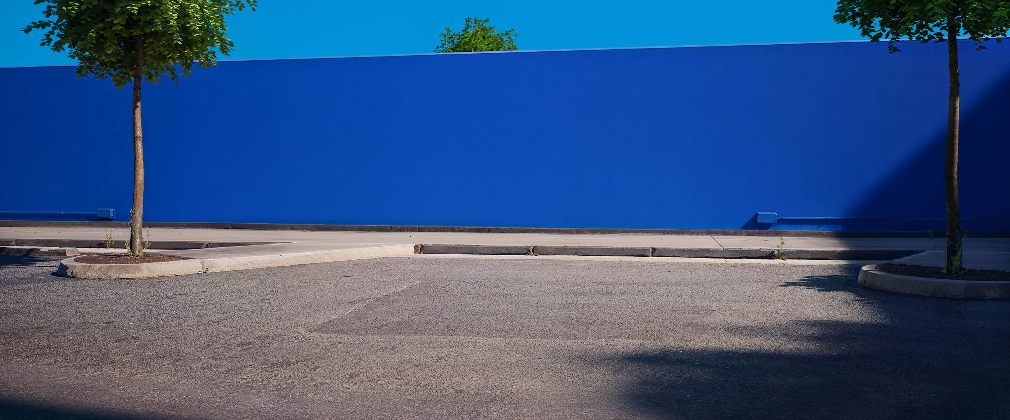 Miejsce postojowe z niebieską ścianą w tle.