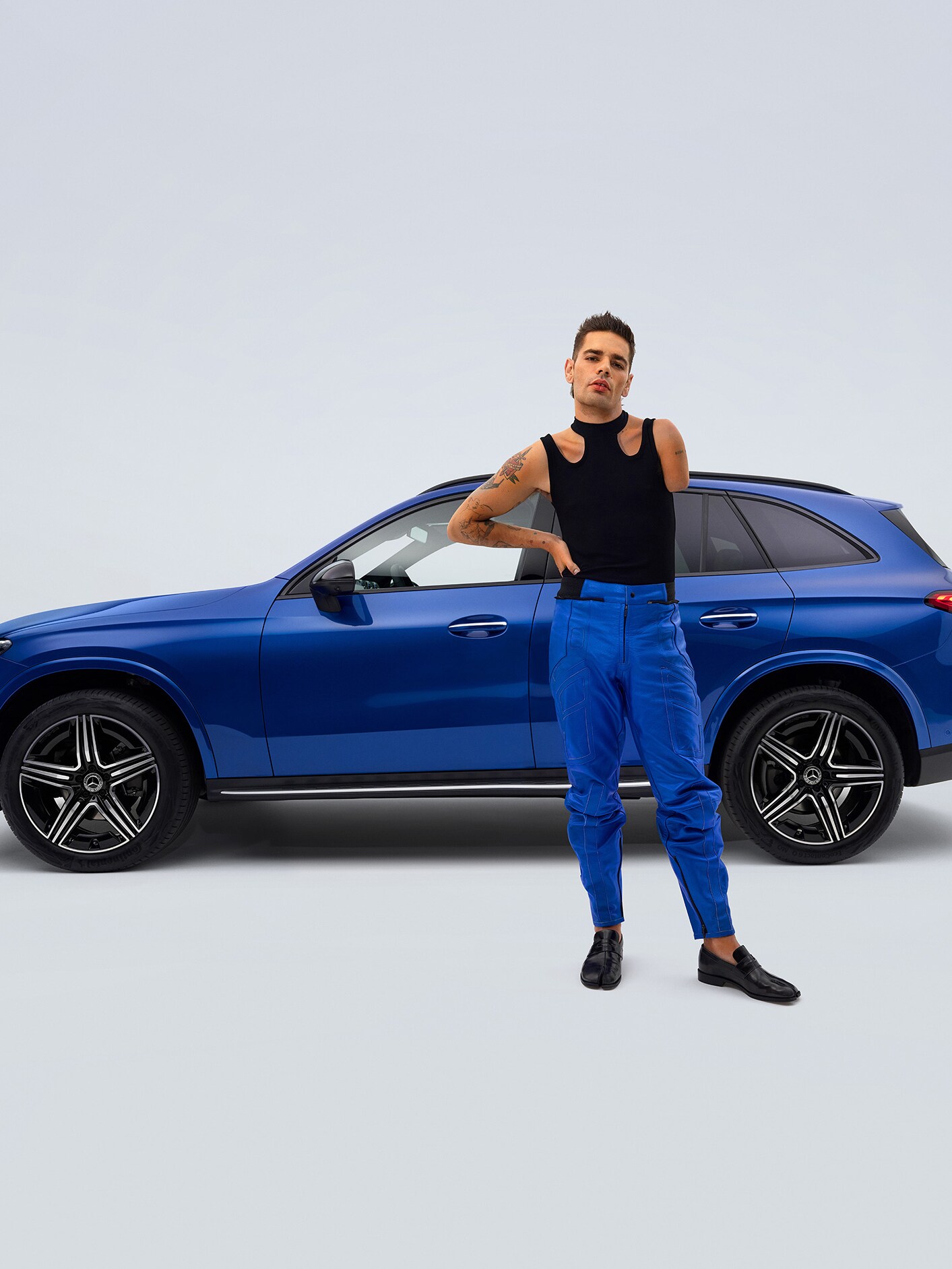 Mercedes-Benz GLC SUV w widoku bocznym i mężczyzna z niepełnosprawnością na pierwszym planie.