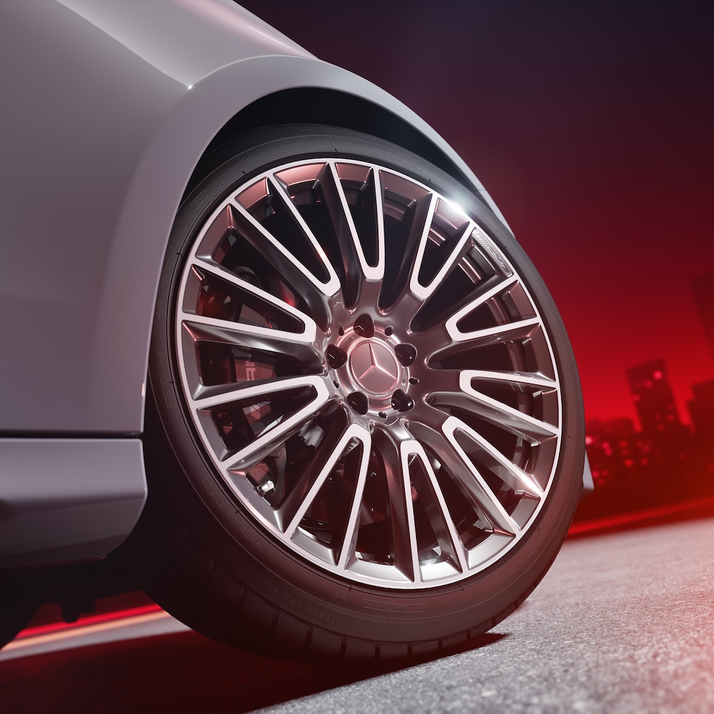 Zbliżenie na kutą obręcz AMG z wysokowydajnym układem hamulcowym AMG z tarczami kompozytowymi i lakierowanymi na czerwono zaciskami.