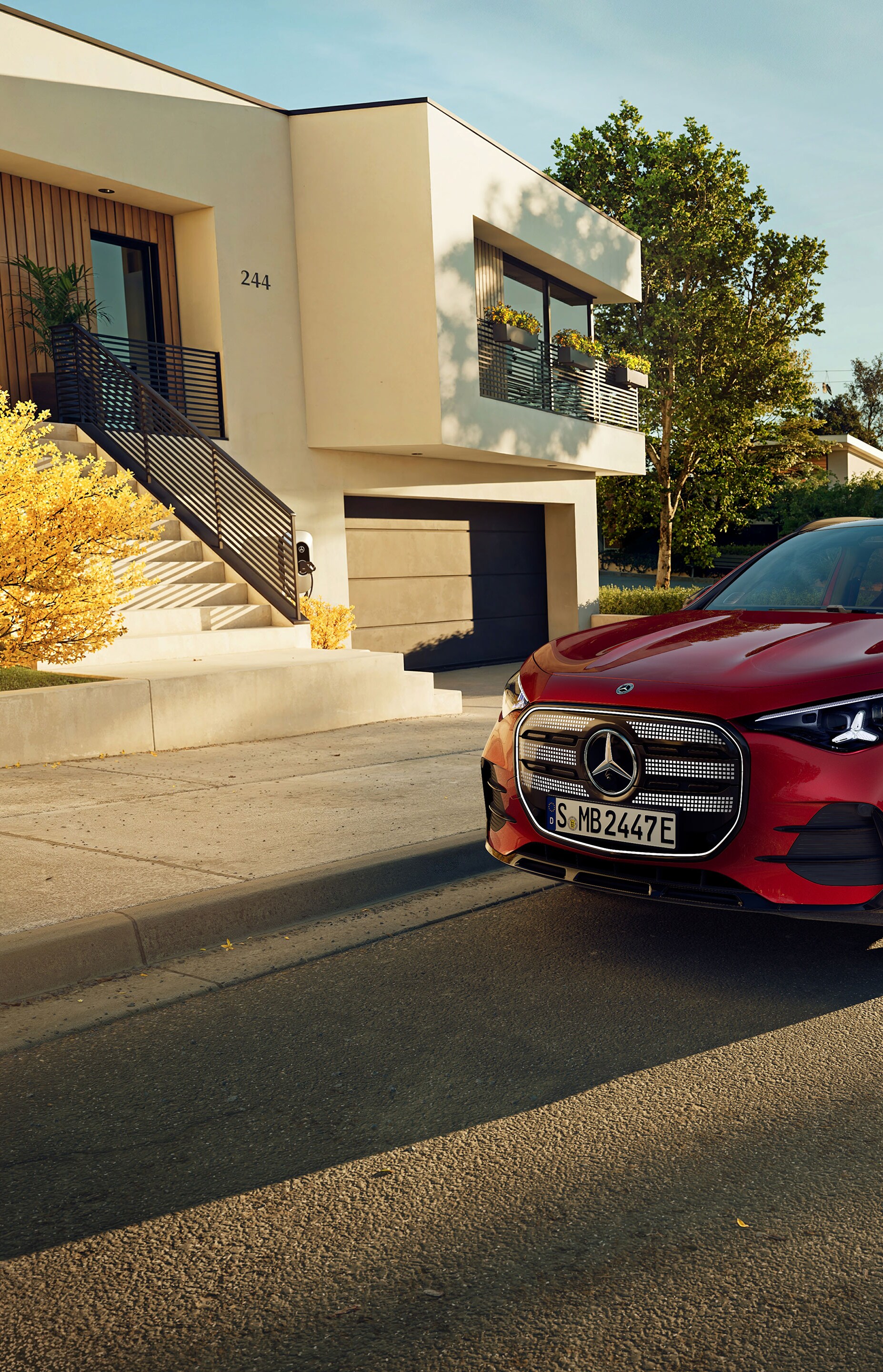 Całkowicie nowy, elektryczny GLA marki Mercedes-Benz zaparkowany na miejscu parkingowym obok kawiarni.