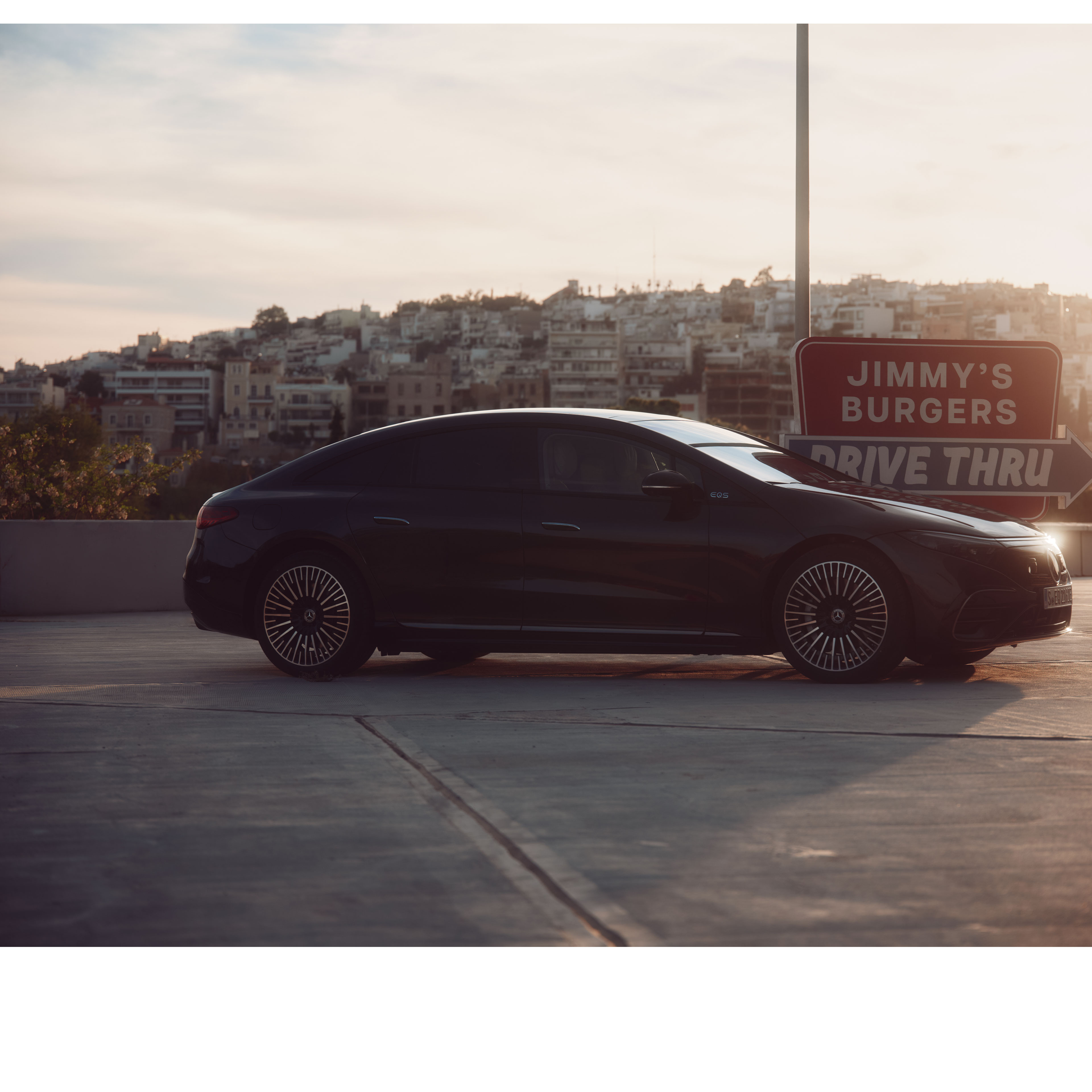 Jazda autonomiczna | EQS | Mercedes-Benz Mercedes-Benz EQS w kolorze czarnym stoi zaparkowany obok restauracji.