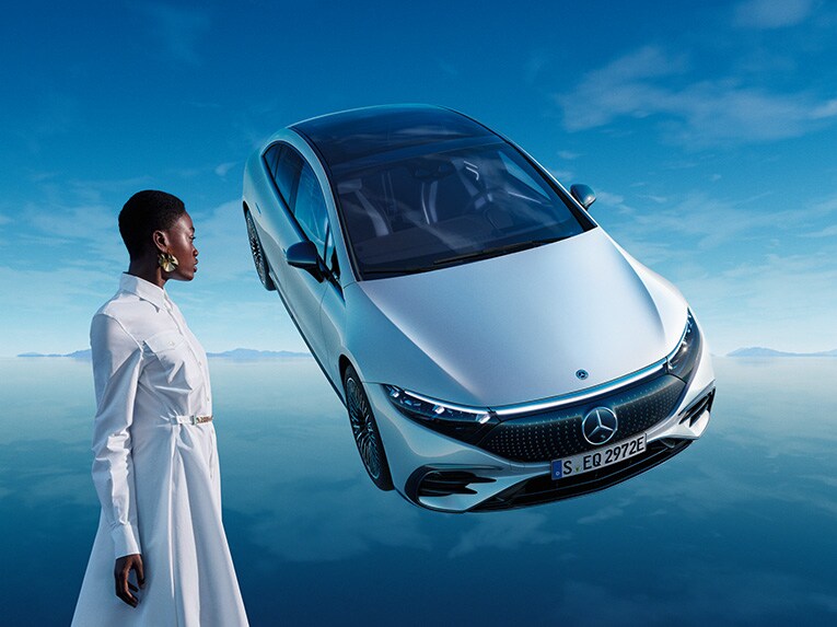 Konieta patrzy na zawieszony w powietrzu model EQS od Mercedes-Benz.