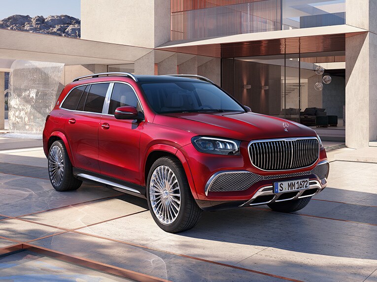 Czerwony Mercedes-Maybach GLS na tle nowoczesnego domu.
