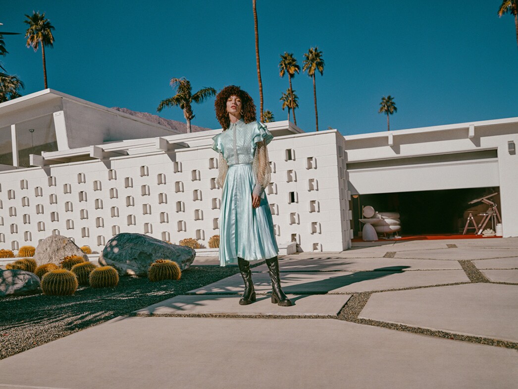 Kobieta stoi na podjeździe przed garażem.