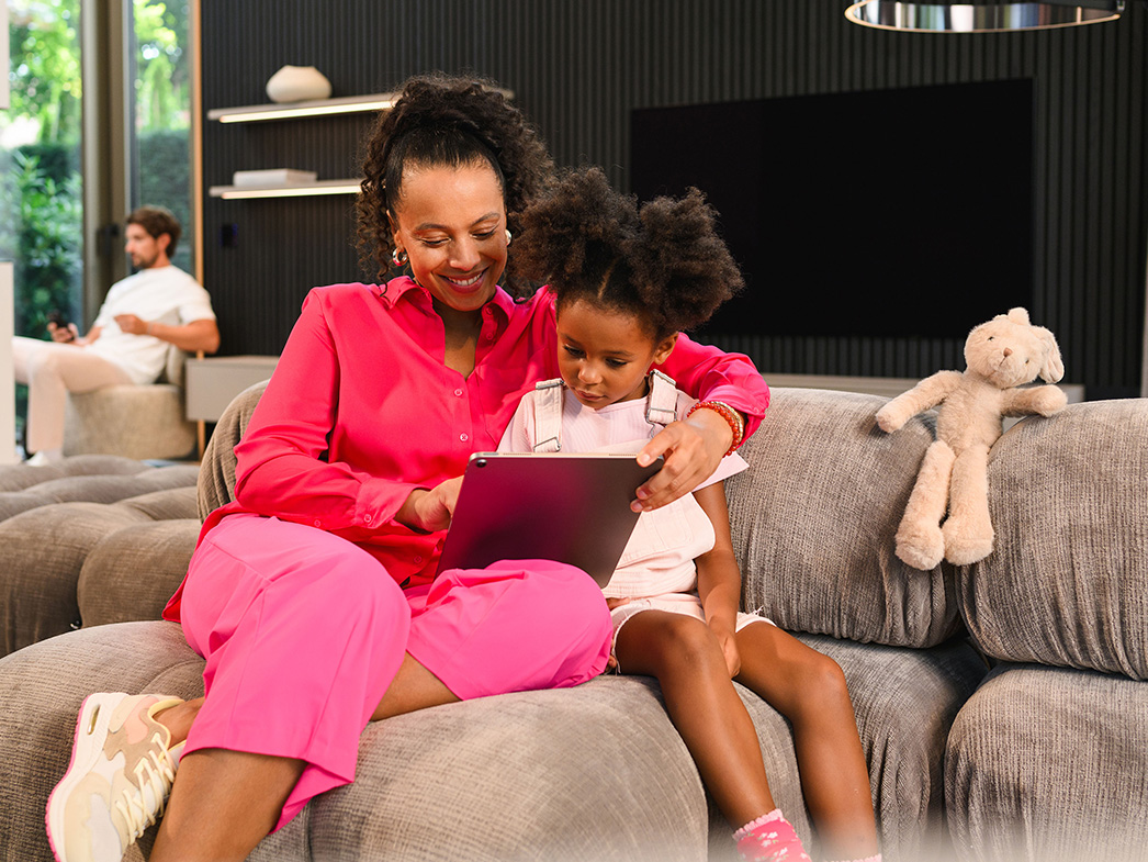 Mercedes-Benz Finance | Mercedes-Benz Matka z córką siedzące na kanapie korzystają z urządzenia mobilnego.