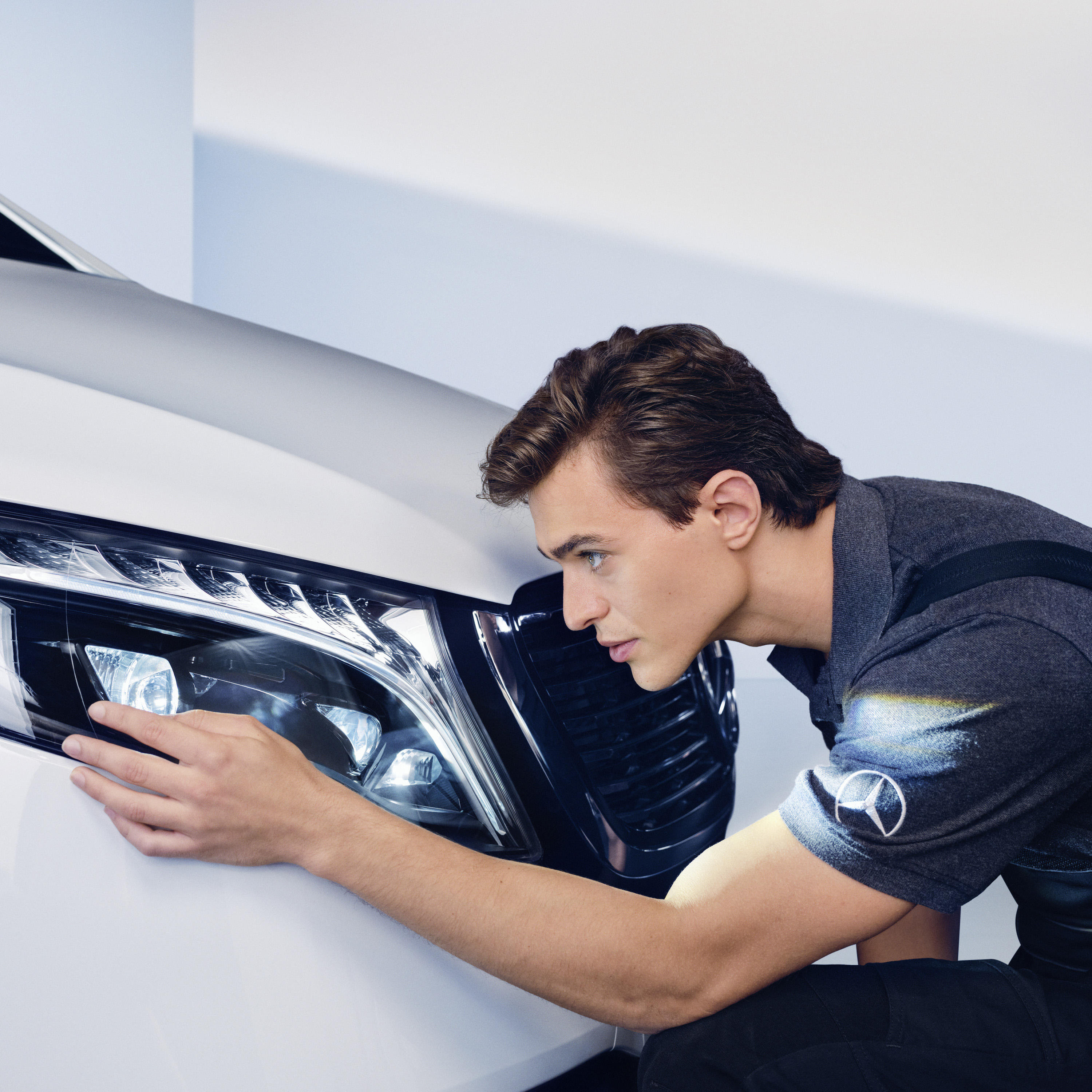 SmallRepair | Mercedes-Benz Pracownik serwisu sprawdza reflektor w samochodzie Mercedes-Benz.