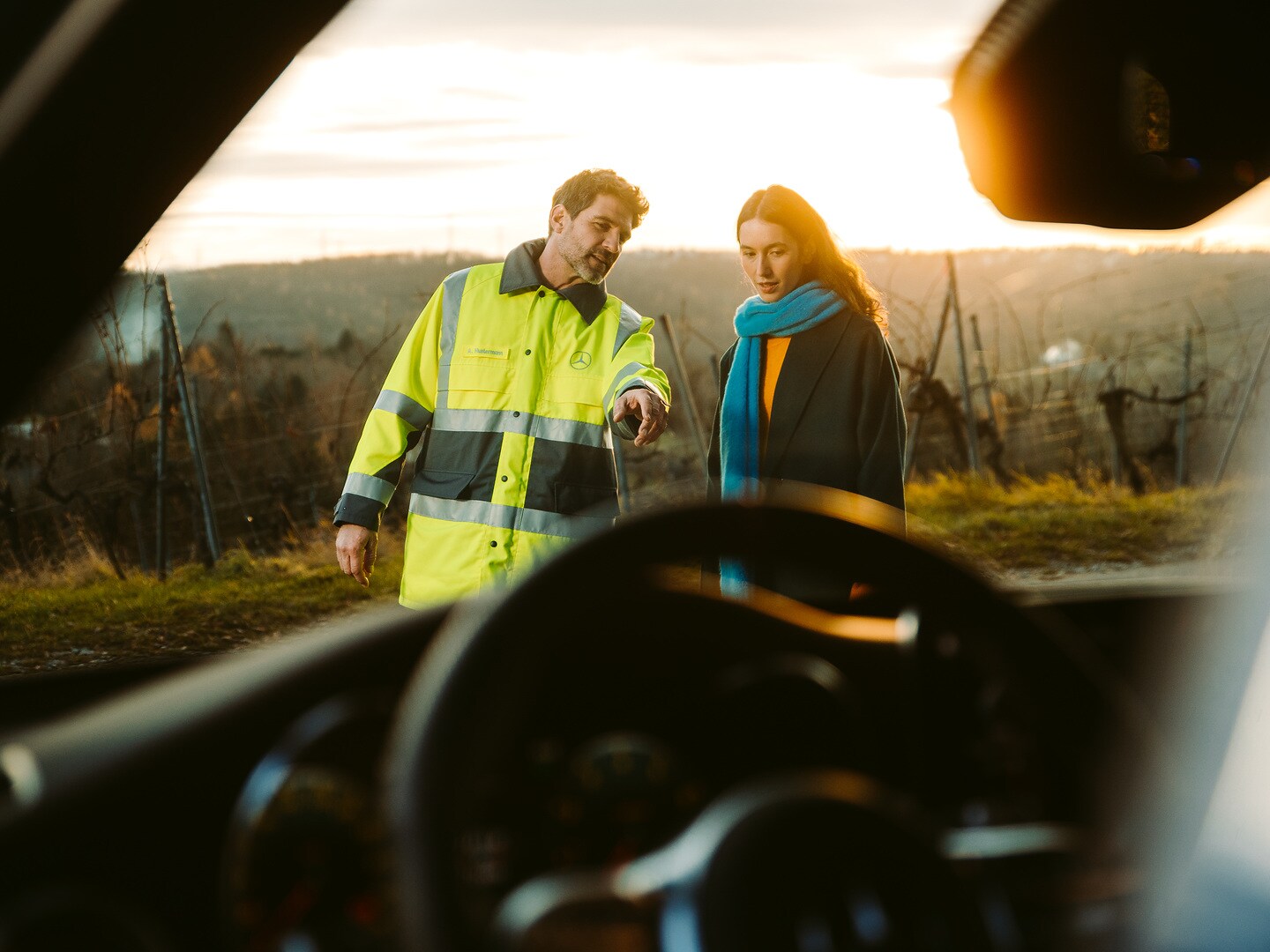 Pracownik Mercedes-Benz pomaga kobiecie, której auto uległo awarii.