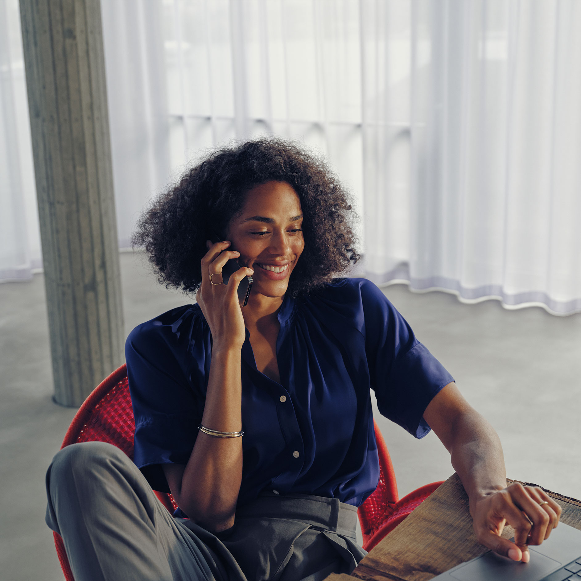 Pytania | Ładowanie | Mercedes-Benz Kobieta siedząca przy stole i rozmawiająca przez telefon.