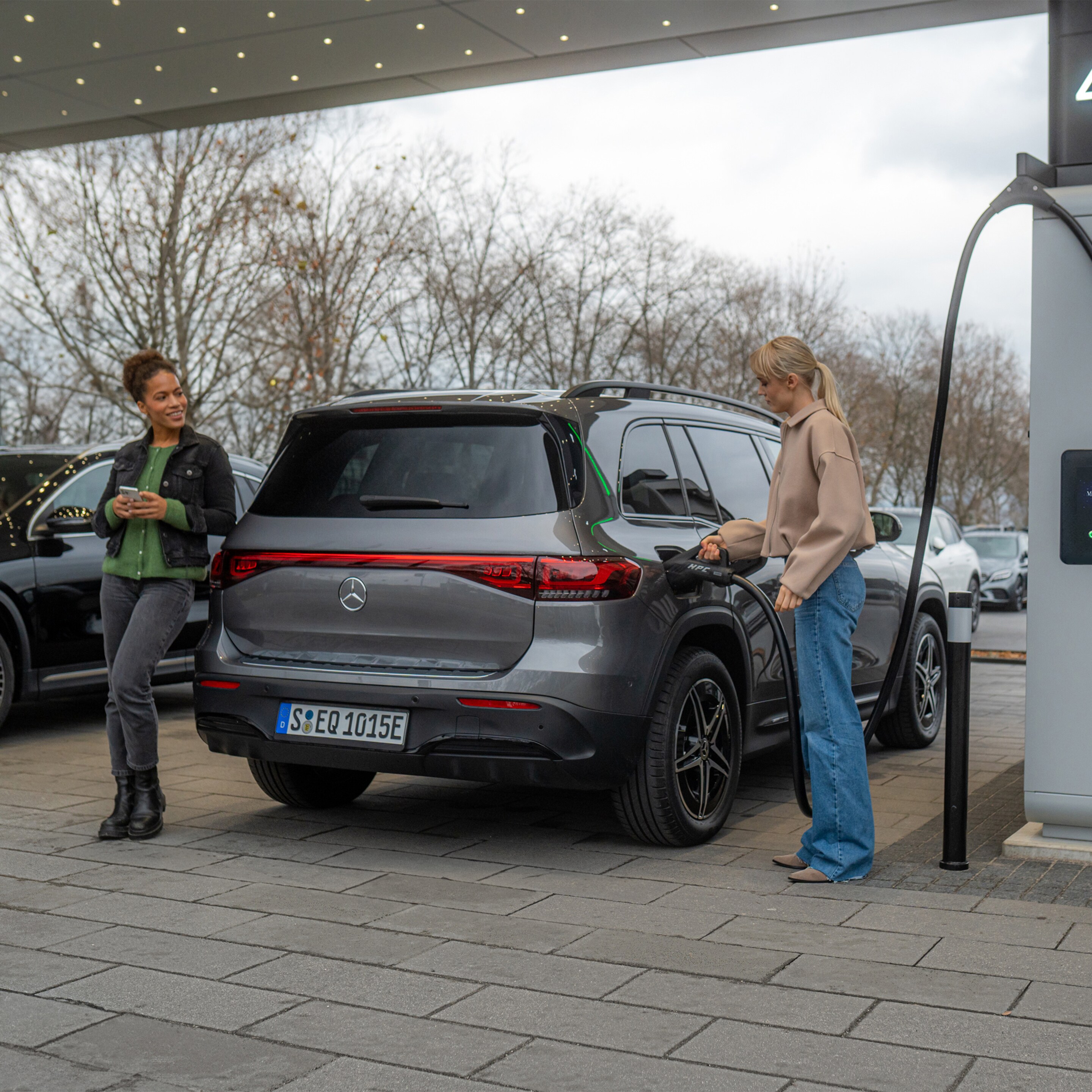 Dwa samochody elektryczne Mercedes-Benz na stacji ładowania.