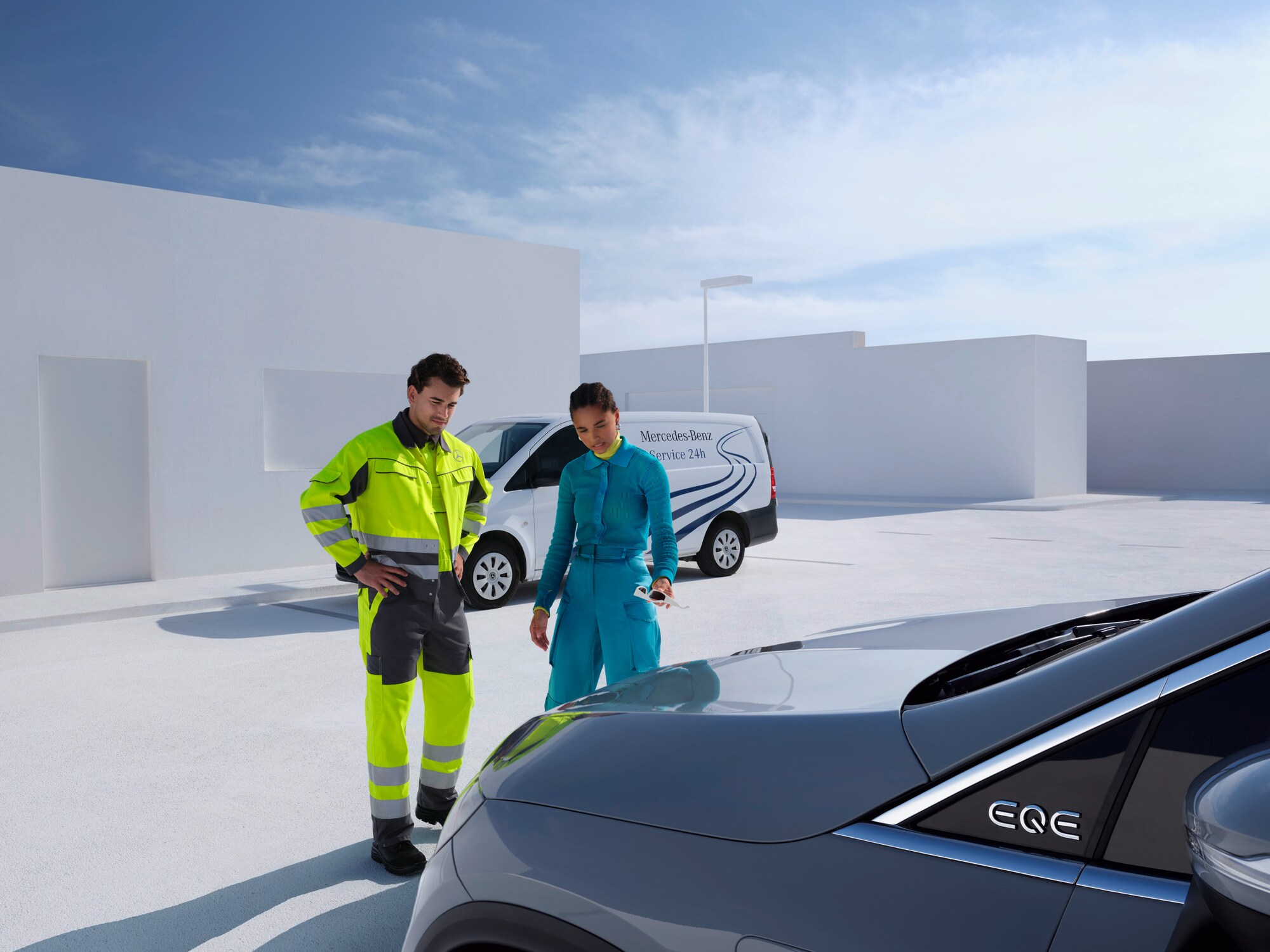 Osoba z Zespołu Wsparcia Mercedes-Benz Service24 konsultujący się z klientem przed jej samochodem Mercedes-Benz.