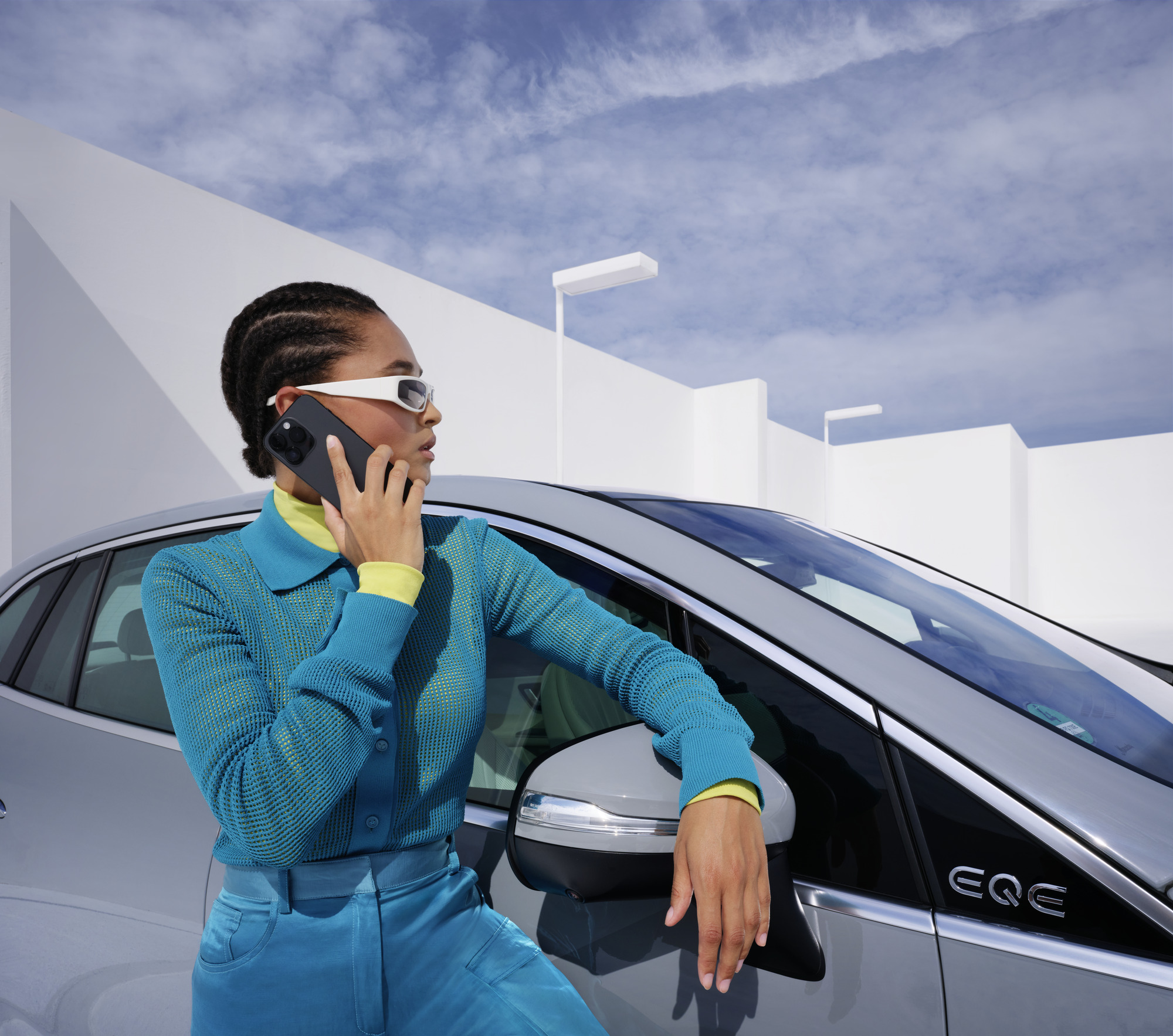 W razie wypadku i awarii | Mercedes-Benz Osoba opierająca się o samochód Mercedes-Benz z telefonem w ręce.