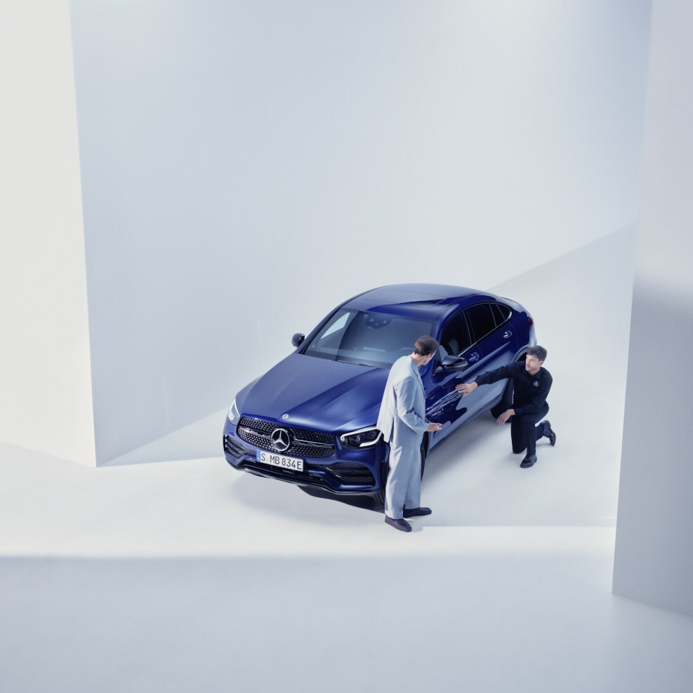 Mężczyzna rozmawiający z serwisantem Mercedes-Benz przy swoim modelu Mercedes-Benz.