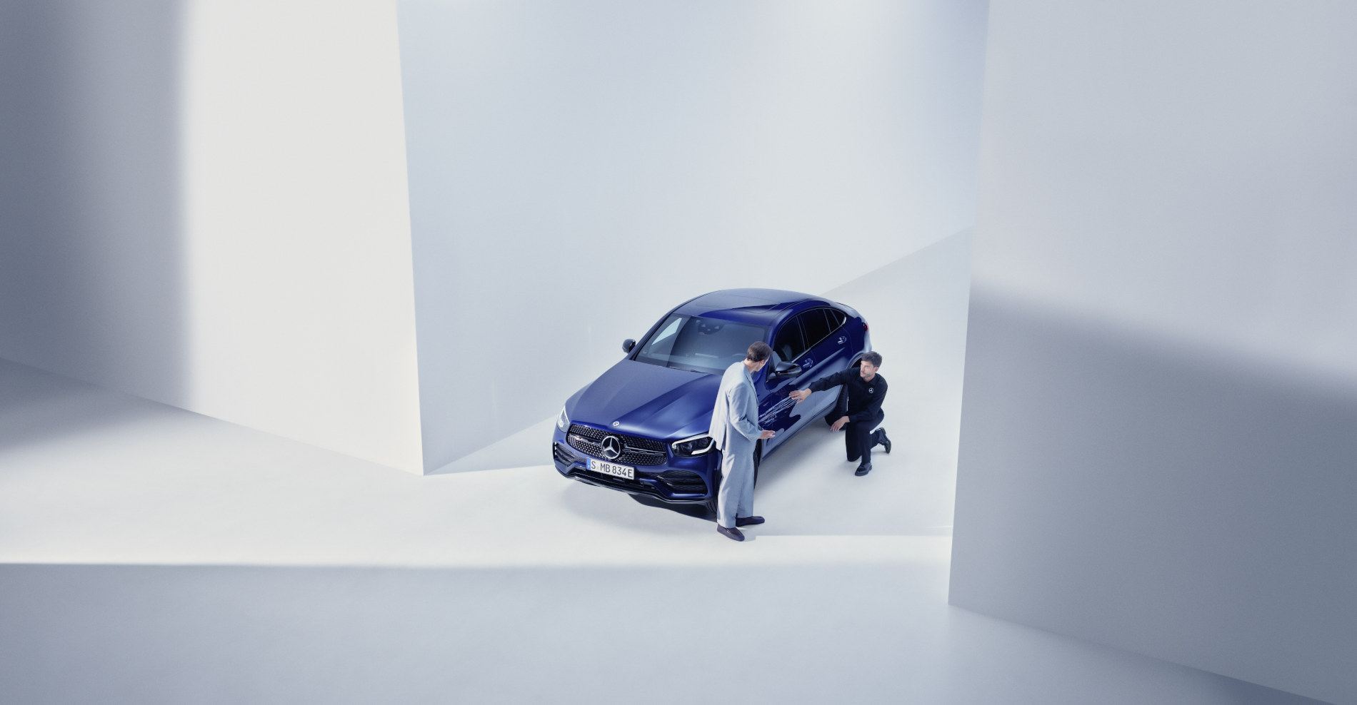 Pomoc drogowa i pomoc w dochodzeniu roszczeń | Mercedes-Benz Mężczyzna rozmawiający z serwisantem Mercedes-Benz przy swoim modelu Mercedes-Benz.