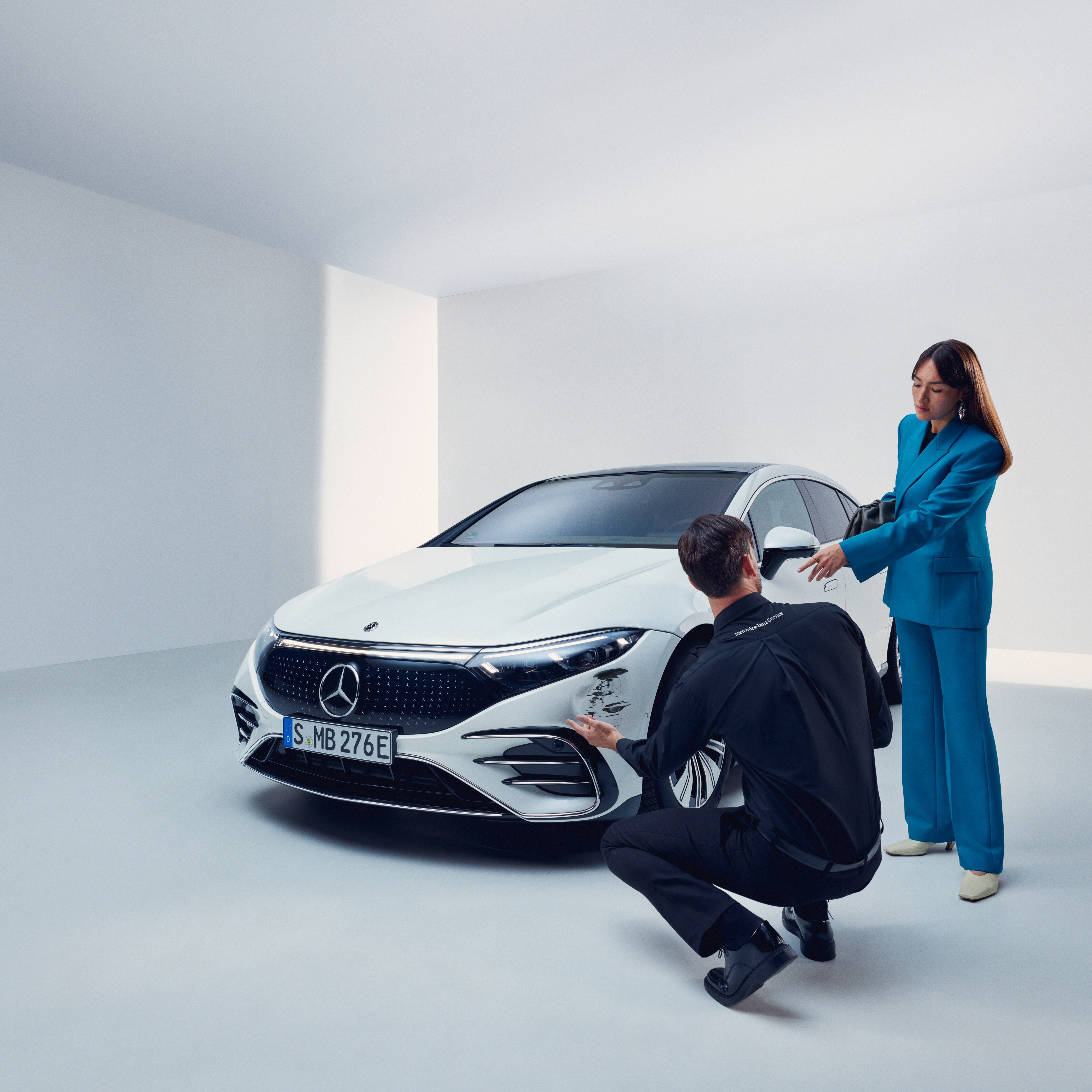 Mężczyzna dokonuje przeglądu należącego do pojazdu Mercedes-Benz.