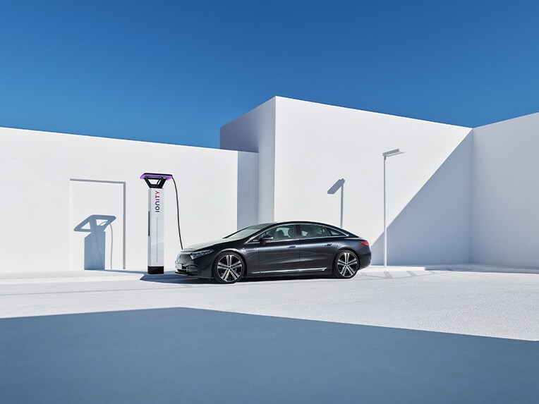 Mercedes-EQ EQS stoi przy stacji ładowania.