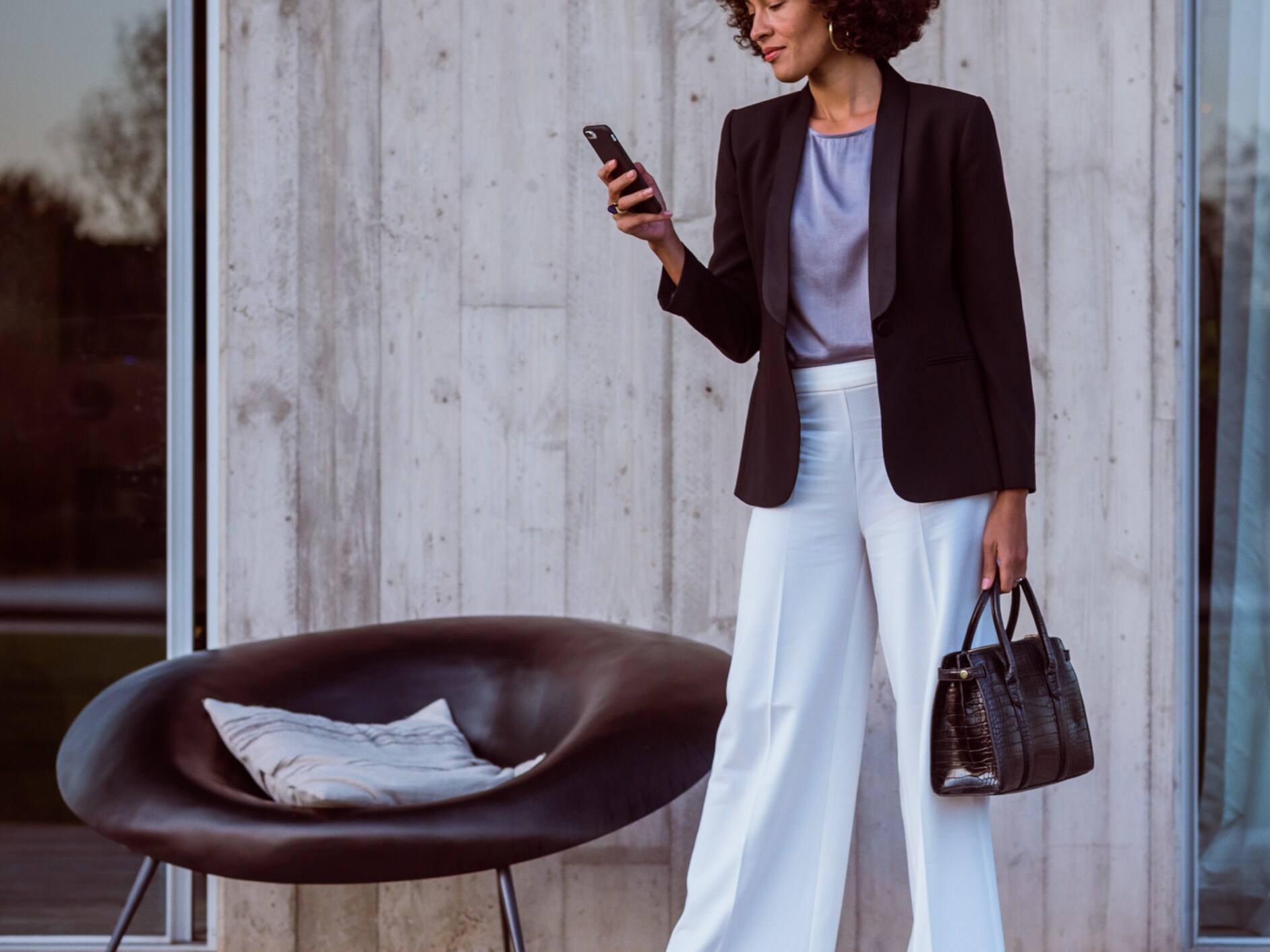 Kobieta łączy się ze swoim samochodem Mercedes-Benz za pomocą smartfona, aplikacji Mercedes-Benz i swojego konta Mercedes me ID.