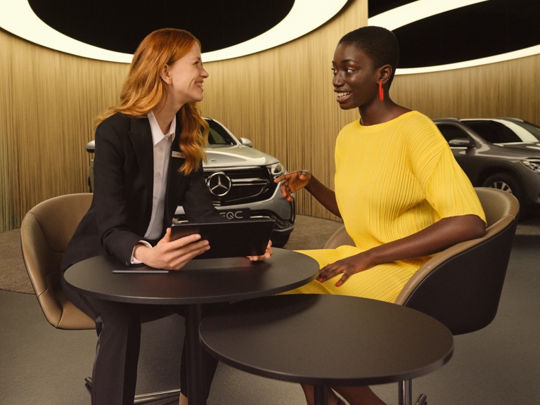 Cyfrowe Dodatki dla klientów biznesowych. Dwie kobiety rozmawiają w salonie Mercedes-Benz.