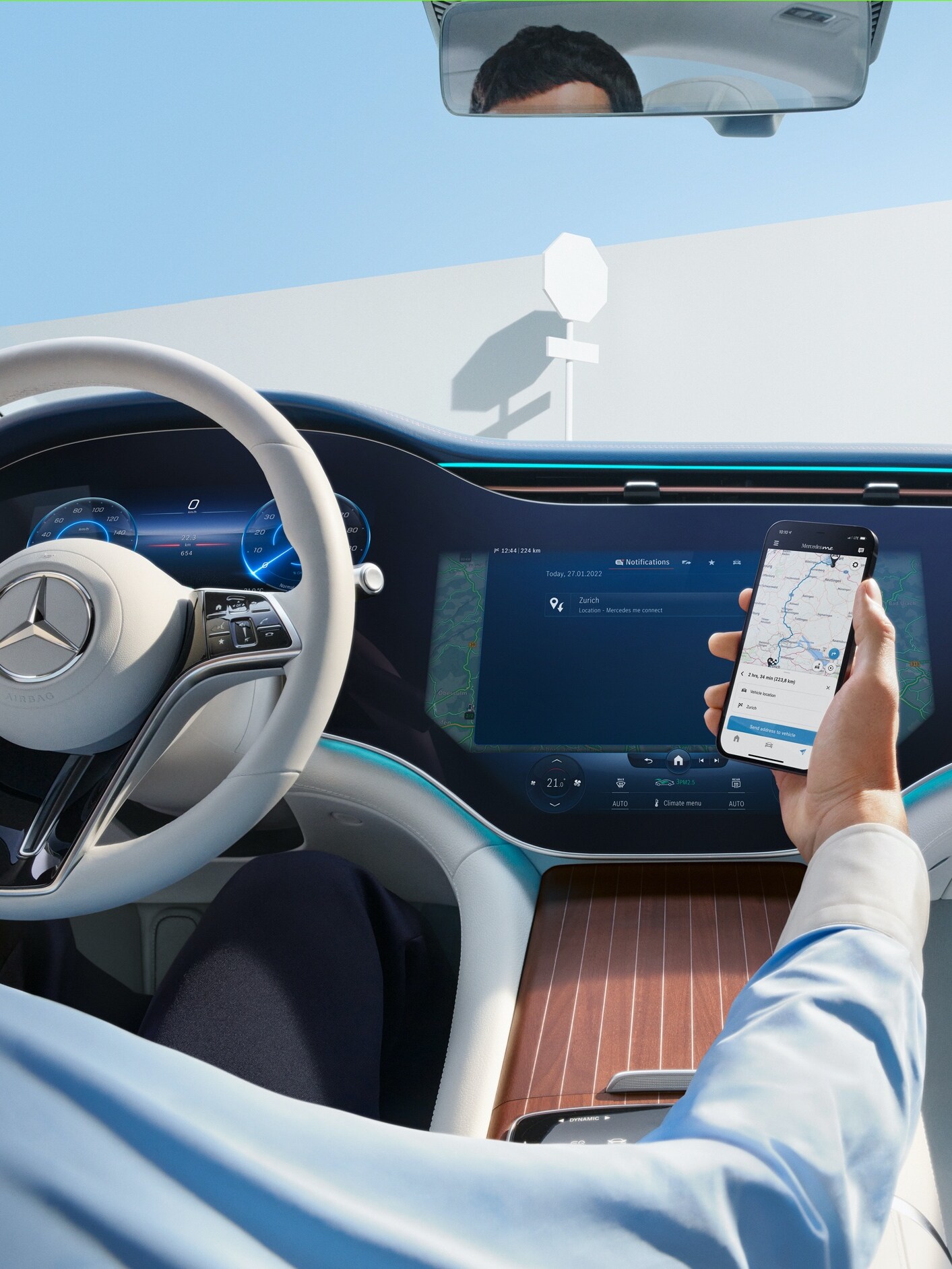 Mężczyzna przekazuje wybraną trasę ze swojego smartfona na ekran MBUX Hyperscreen w swoim Mercedesie.