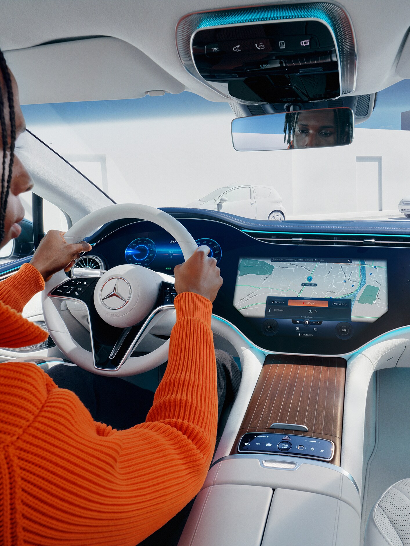 Mężczyzna spogląda na ekran multimedialny we wnętrzu Mercedesa.