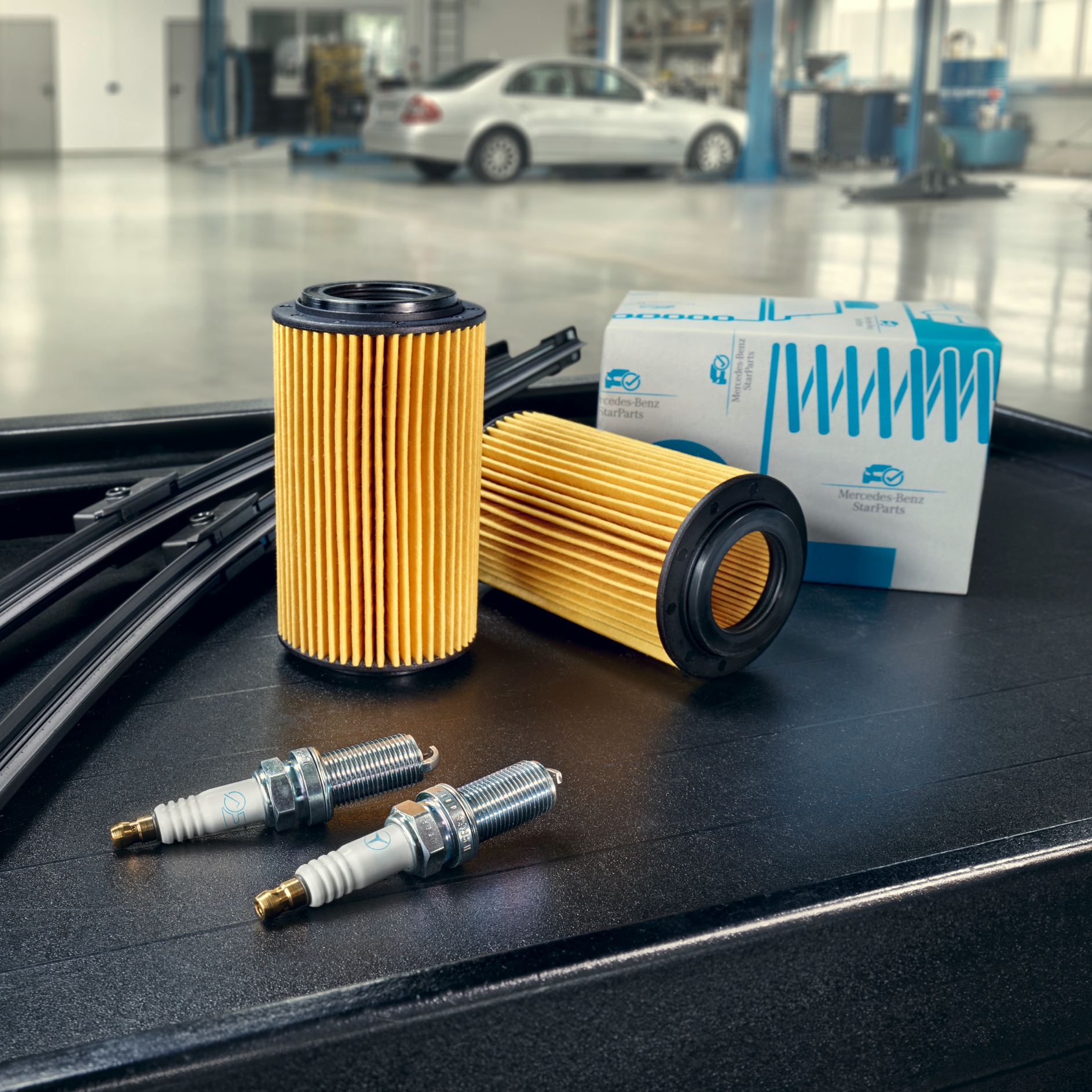 Mercedes-Benz StarParts Części Mercedes-Benz na stoliku w warsztacie.