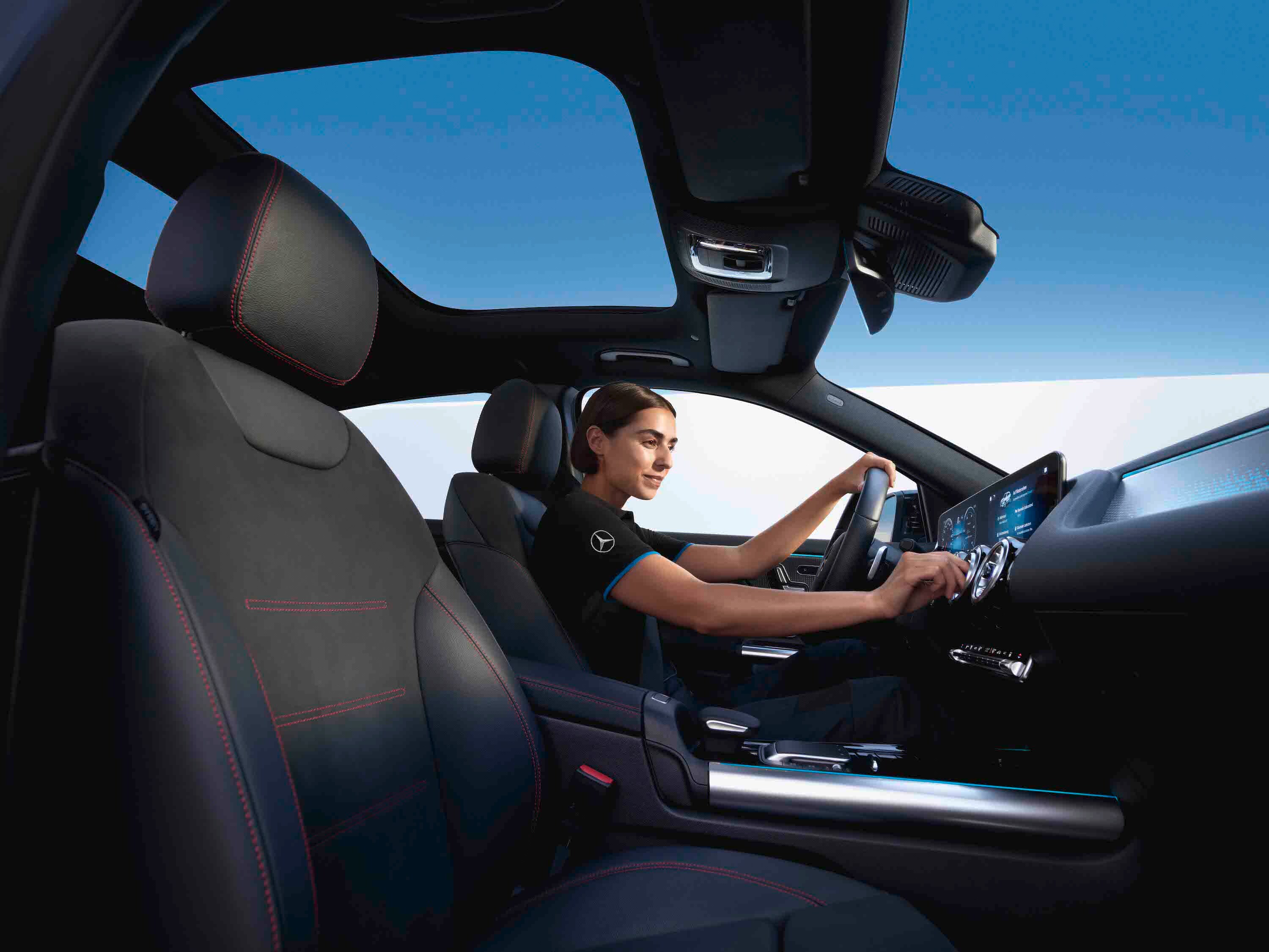 Technik siedzi w pojeździe Mercedes-Benz i sprawdza filtr kabinowy.