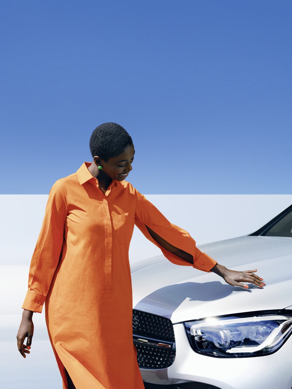 Osoba stojąca obok pojazdu Mercedes-Benz.