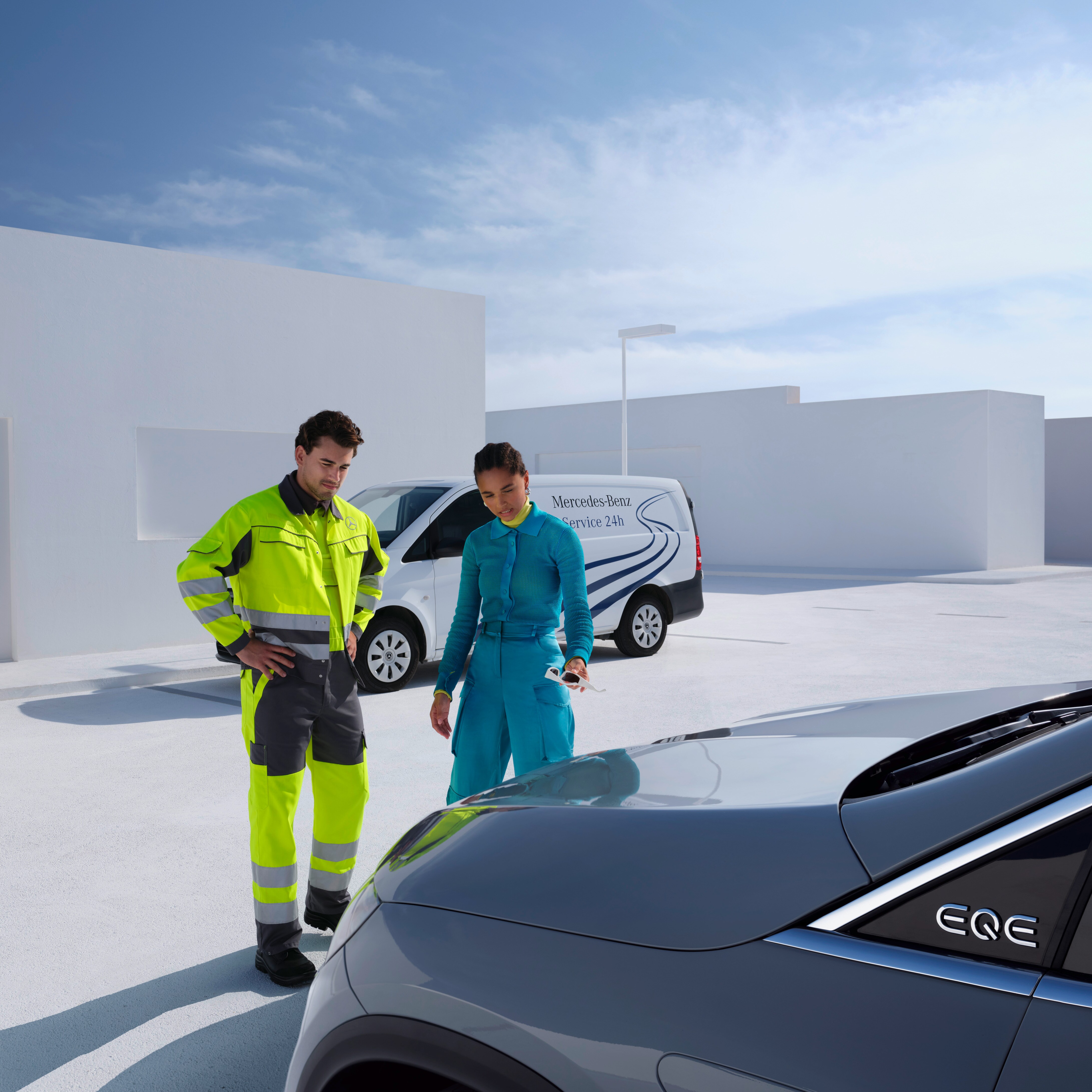 Mężczyzna z zespołu serwisowego Mercedes-Benz i kobieta patrzą na samochód Mercedes-Benz