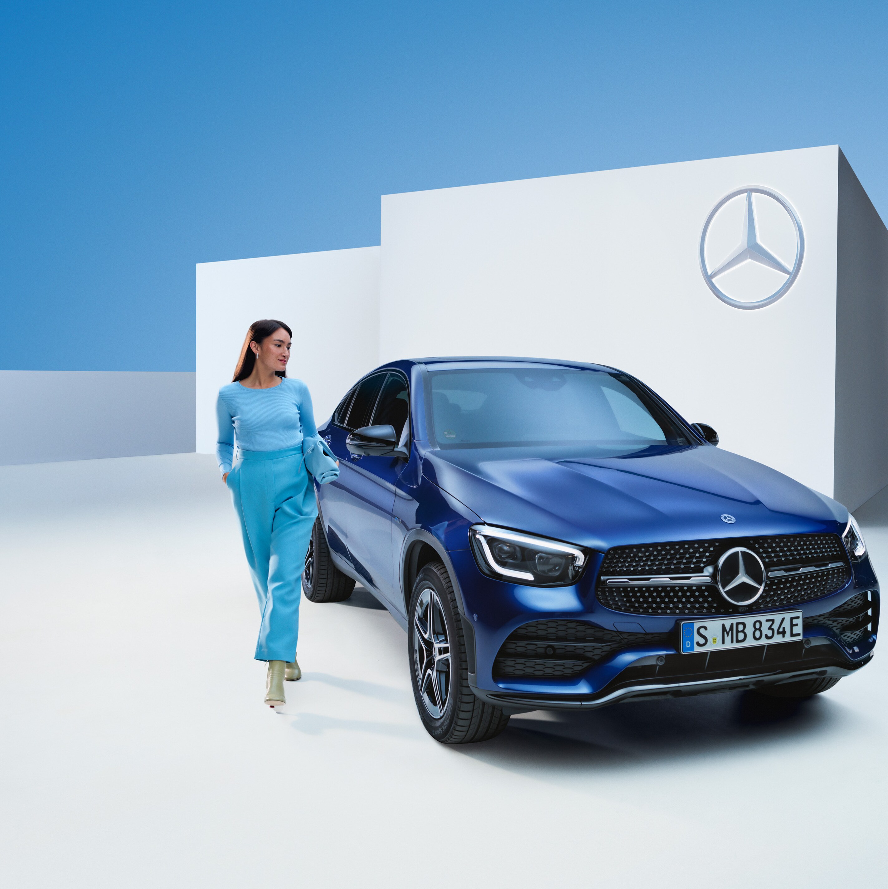 Odprężona kobieta za kierownicą swojego Mercedesa.