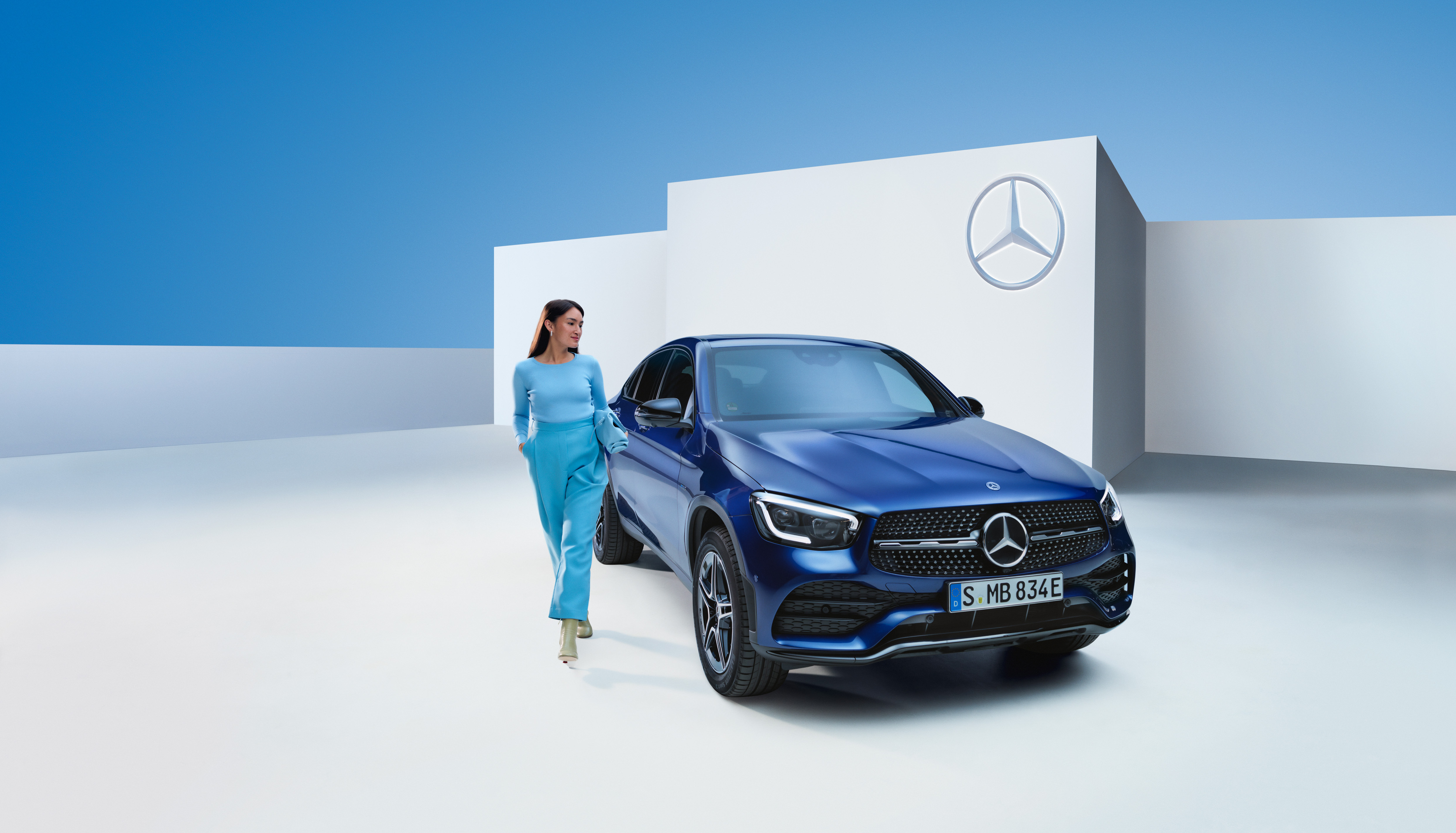 Wsiadaj do auta ze spokojem dzięki gwarancji Mercedes-Benz. Odprężona kobieta za kierownicą swojego Mercedesa.