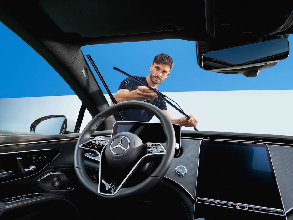 Technik Mercedes-Benz przeprowadzający wymianę wycieraczek przedniej szyby.