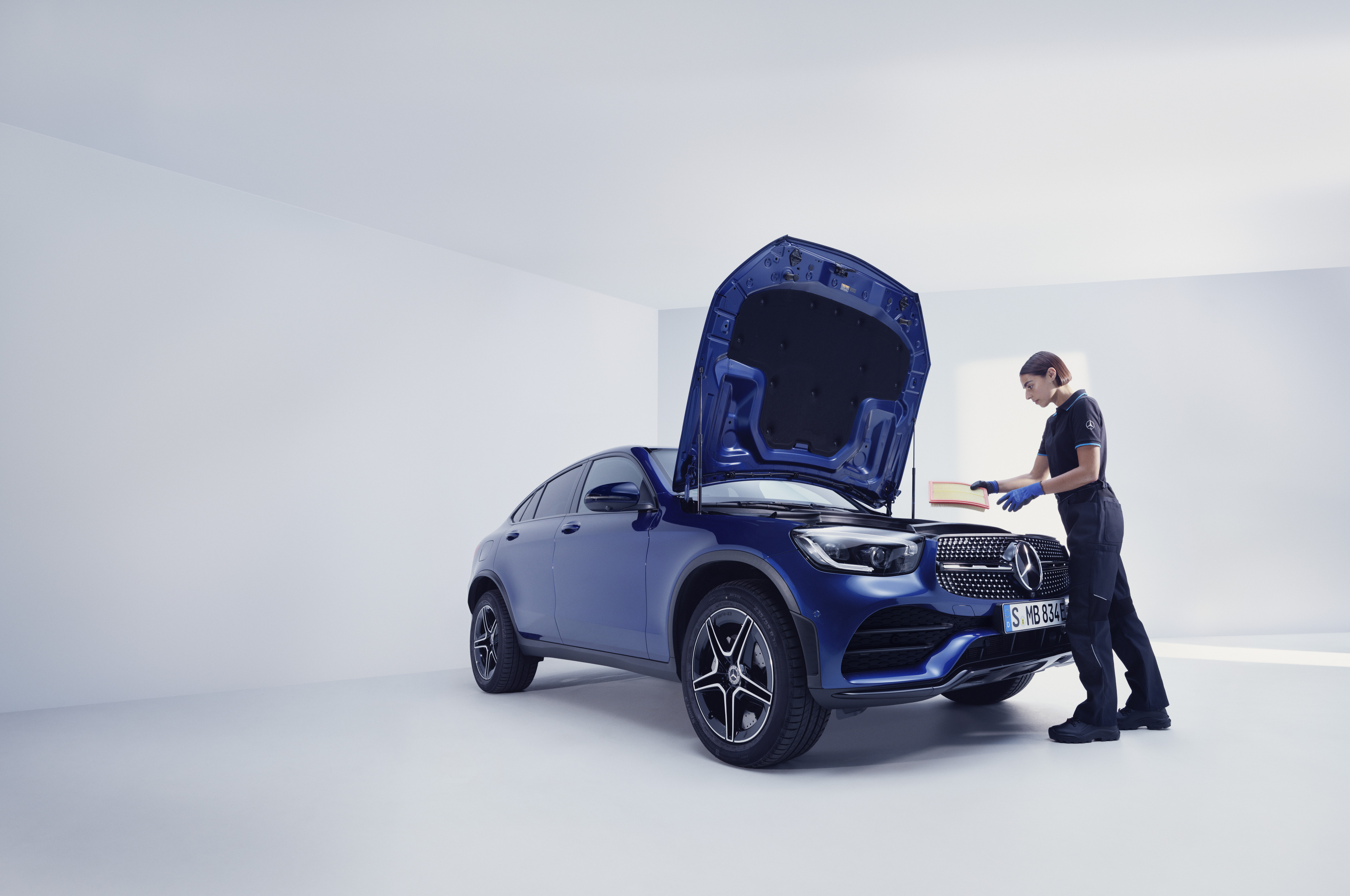 Usługi serwisowe | Mercedes-Benz Mechanik Mercedes-Benz badający samochód Mercedes-Benz.