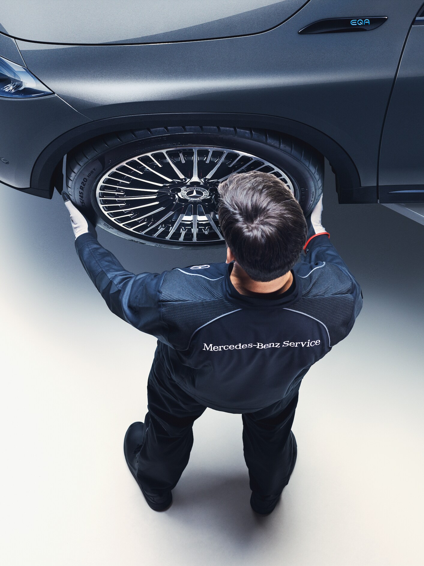 Technik Mercedes-Benz montuje koło Mercedesa EQA.