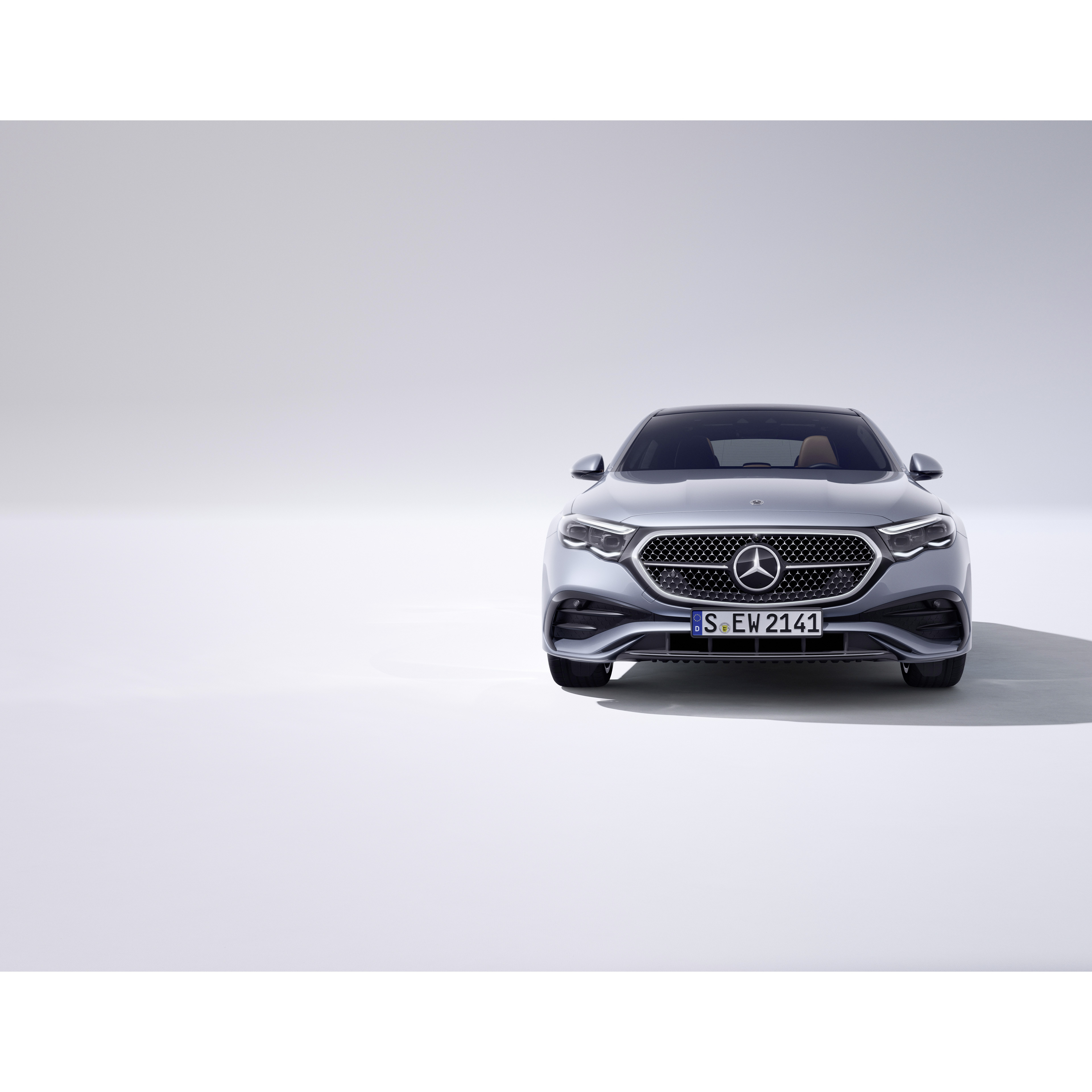Mercedes-Benz Intelligent Drive Klasa E Limuzyna Mercedes-Benz widziana od przodu na jasnoszarym tle.