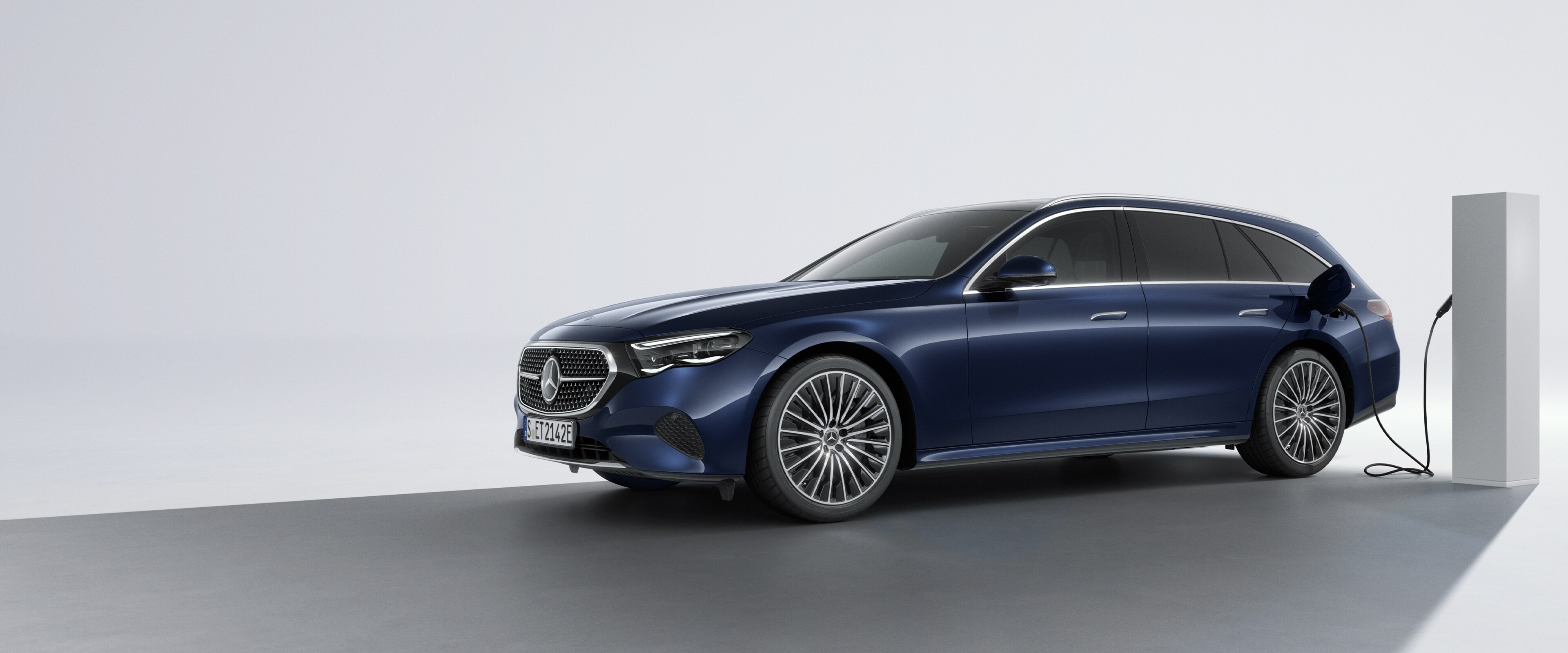 Samochód z napędem hybrydowym plug-in marki Mercedes-Benz w&nbsp;widoku bocznym z&nbsp;tyłu na stacji ładowania.