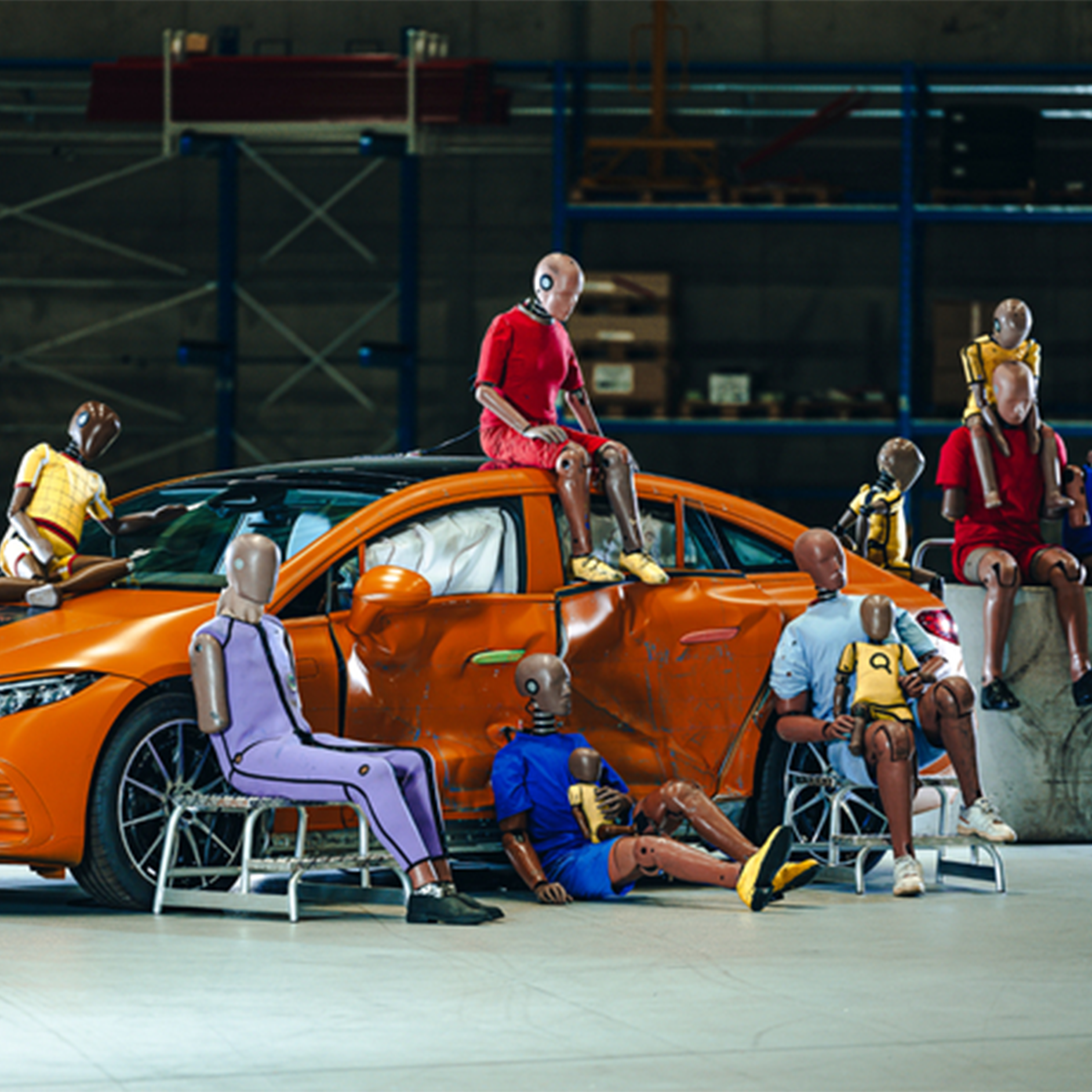 Manekiny do testów zderzeniowych | Bezpieczeństwo | Mercedes-Benz Wiele manekinów do testów zderzeniowych siedzących na i wokół samochodu Mercedes-Benz.