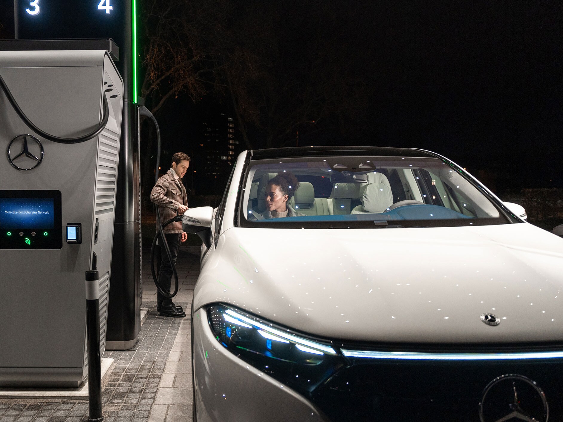 Mercedes-Benz CLA stojący na ulicy, podłączony do stacji ładowania.