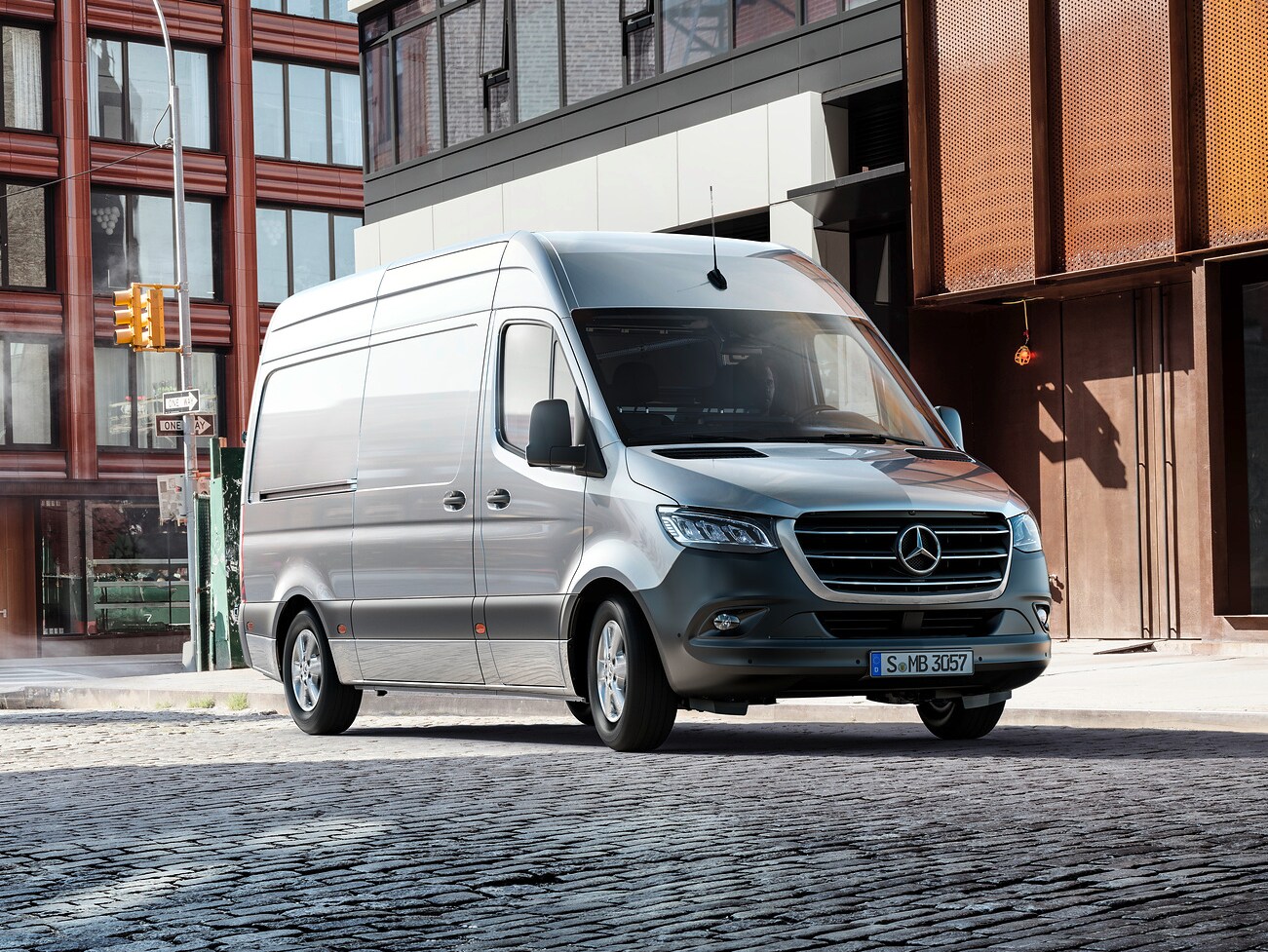 Mercedes-Benz Sprinter zaparkowany przed budynkiem biurowym.