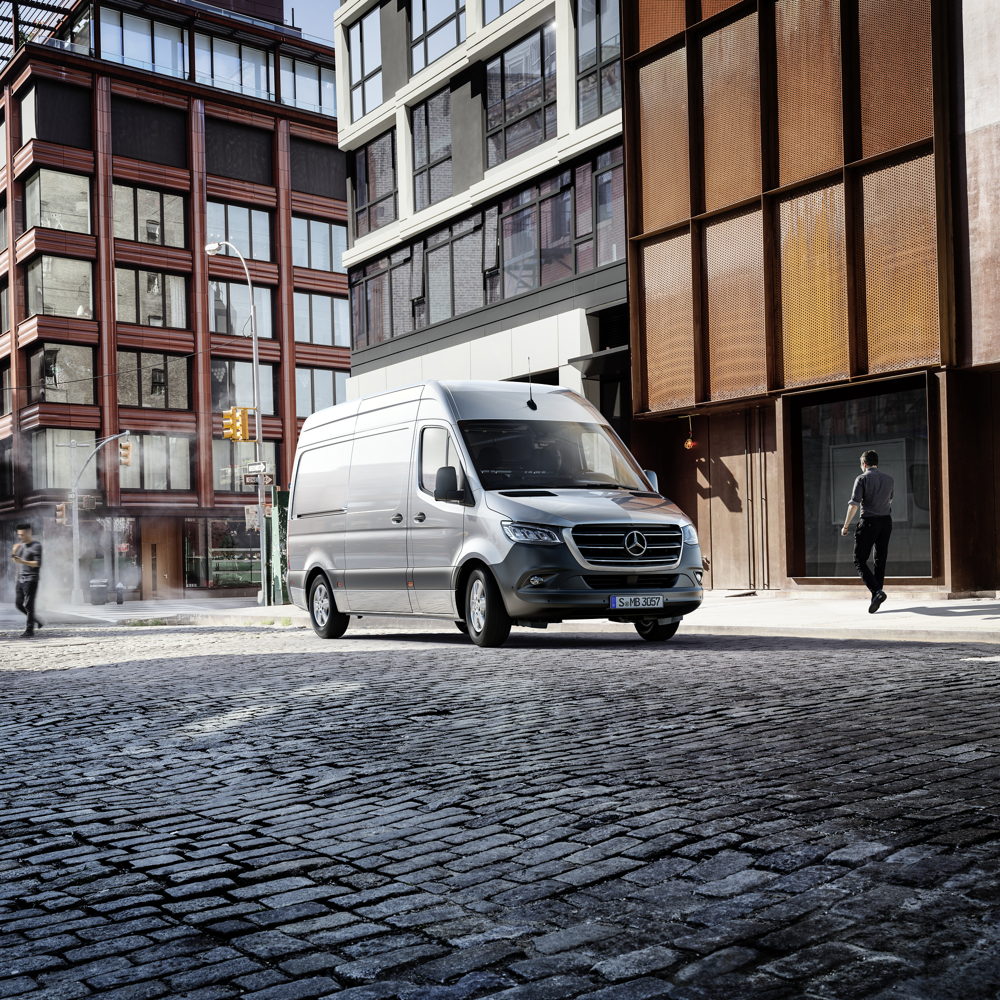 Ekonomiczna Obsługa Pogwarancyjna | Samochody dostawcze Mercedes-Benz Mercedes-Benz Sprinter zaparkowany przed budynkiem biurowym.