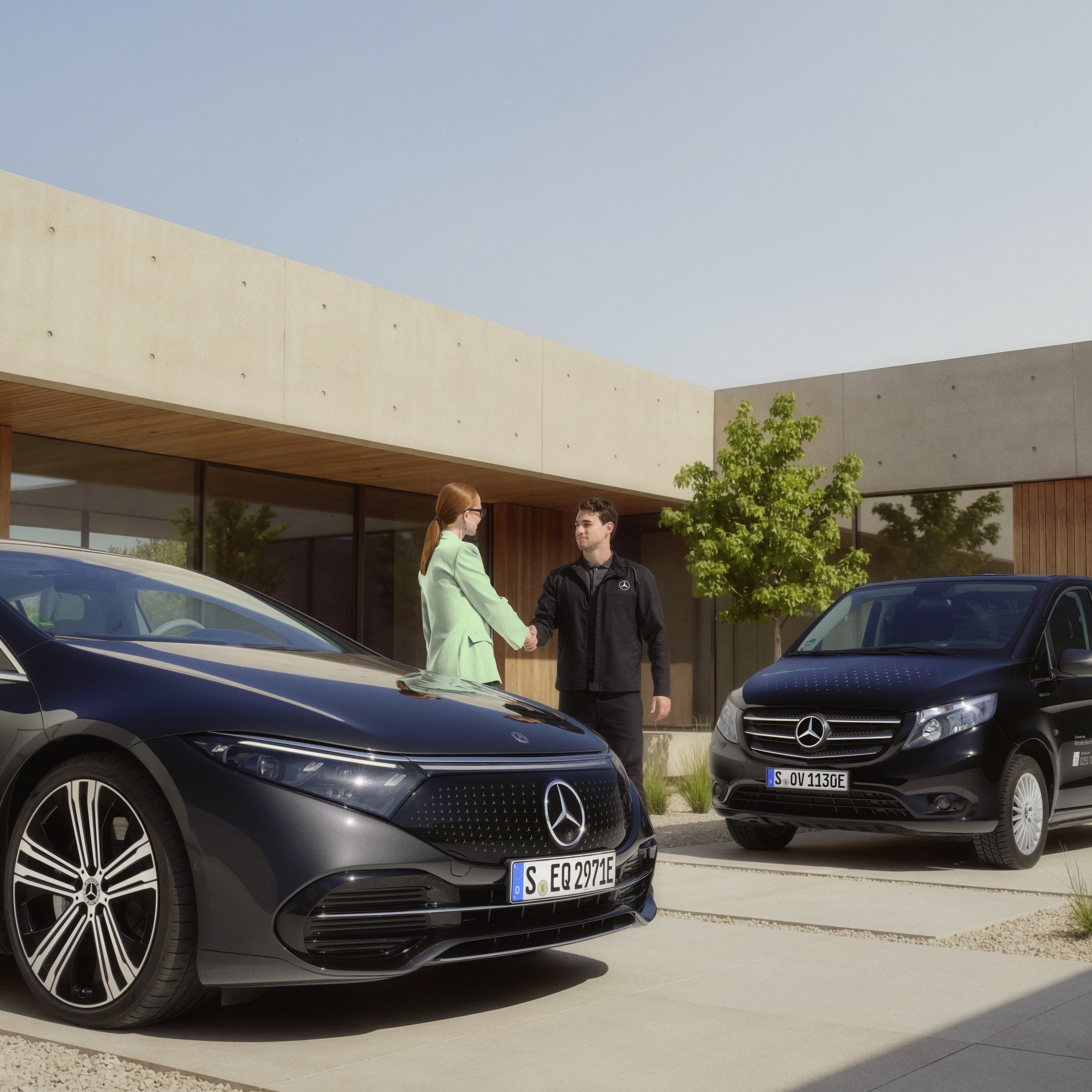 Technik serwisu mobilnego Mercedes-Benz wita klienta uściskiem dłoni przed nowoczesnym domem, przed którym stoi samochód Mercedes-Benz, a obok niego znajduje się samochód serwisowy.