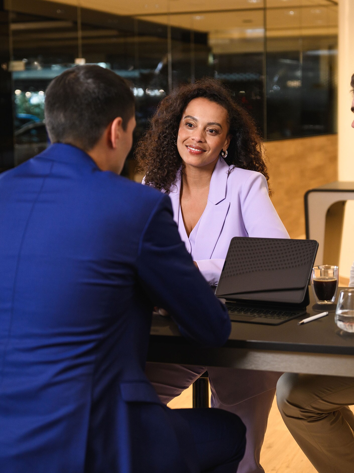 Trzy osoby siedzące przy stole i prowadzące dyskusję.